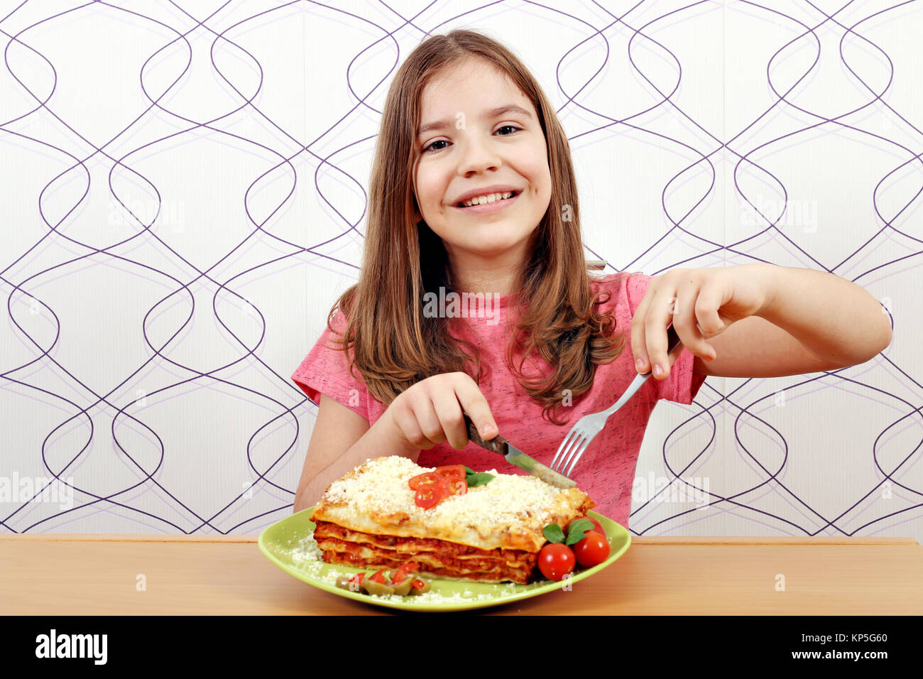 Hungrige kleine Mädchen essen lazagne Stockfoto