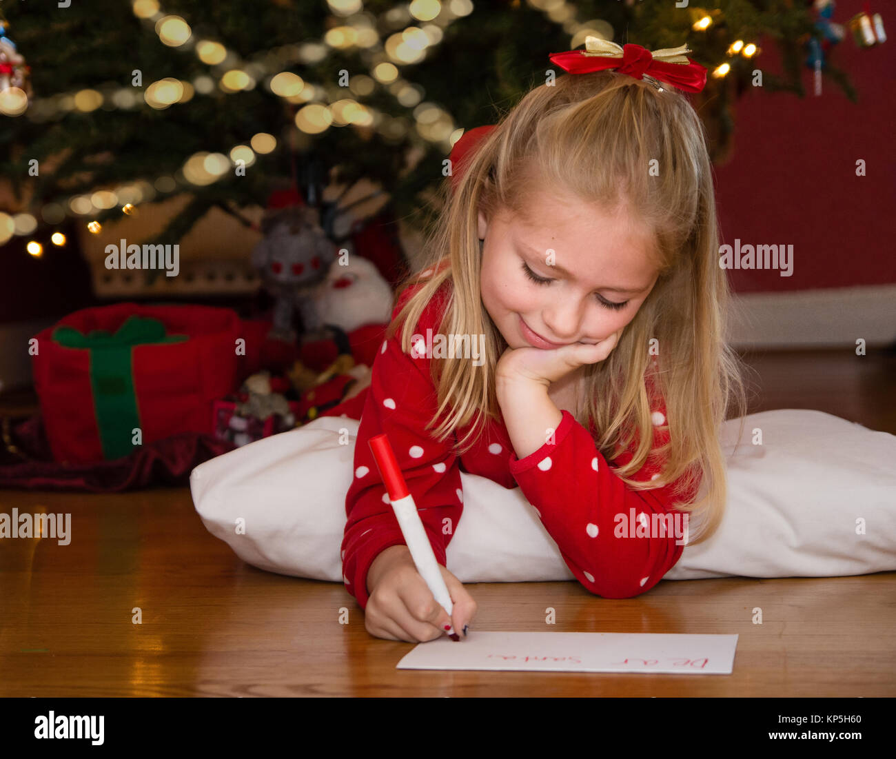 Adorable Schule Alter Mädchen schreiben Hinweis zu Santa auf Weihnachten zu verlassen Stockfoto