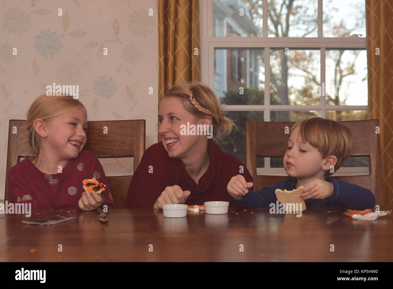Mutter mit 2 Kinder dekorieren Kekse Stockfoto