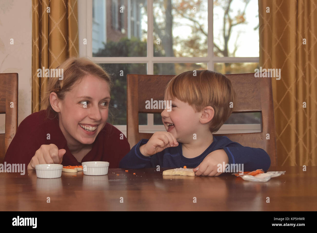Mutter und Sohn saß in der Küche zusammen Dekorieren Cookies Stockfoto