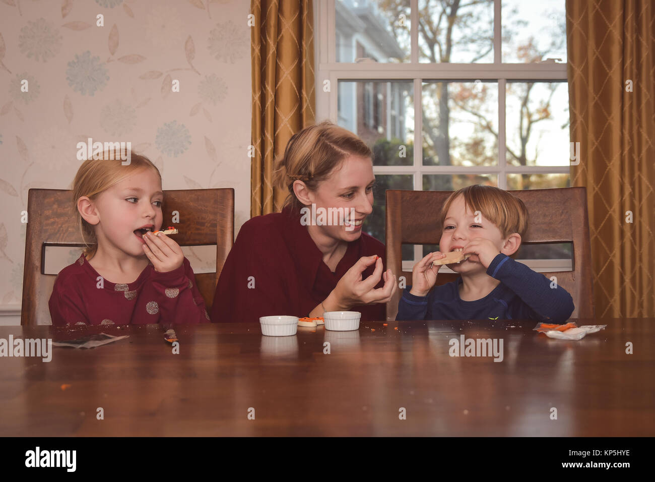 Mutter mit 2 Kinder dekorieren Kekse Stockfoto