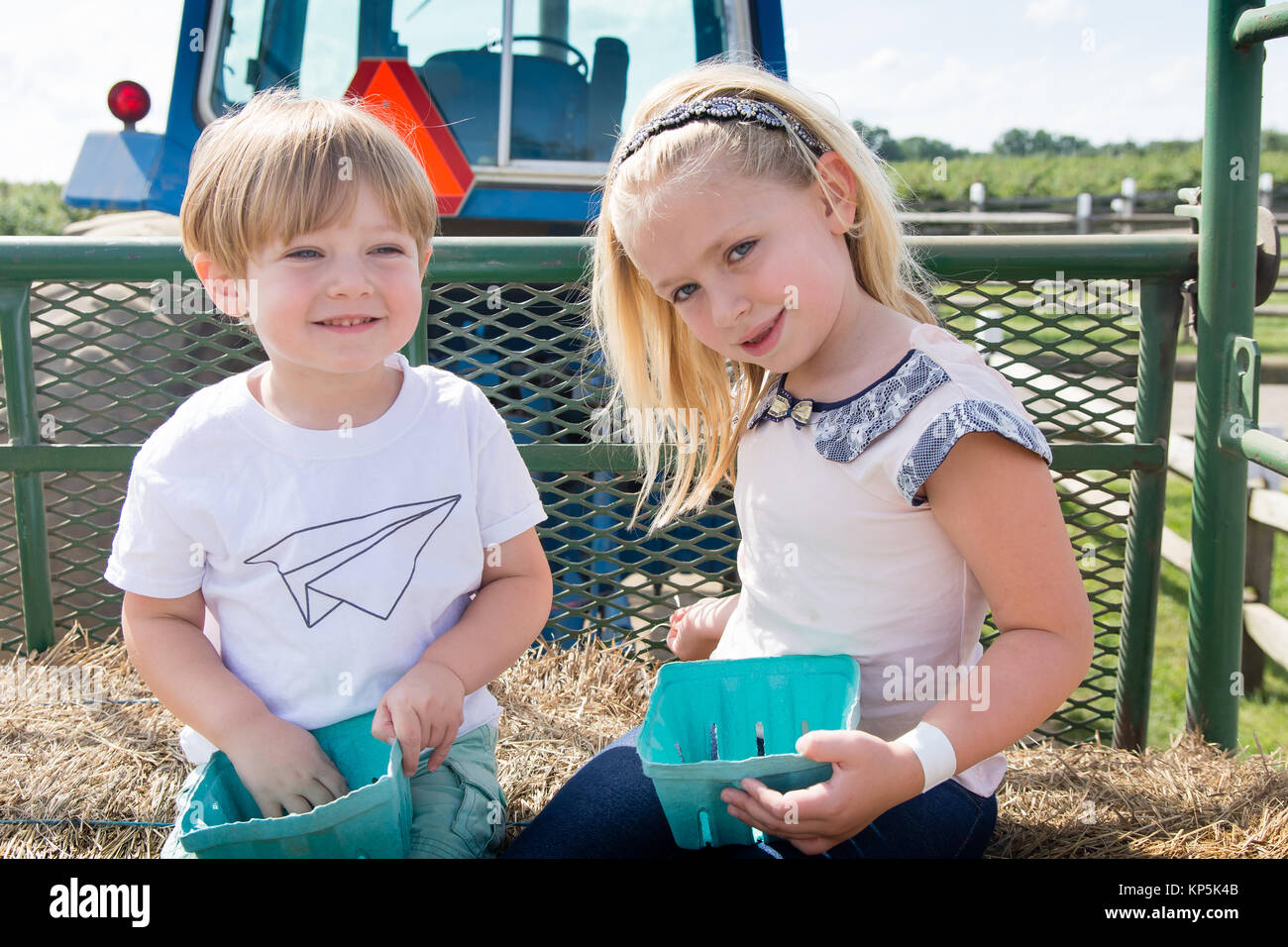 Bruder und Schwester Geschwister zusammen sitzen auf hayride Traktor Stockfoto