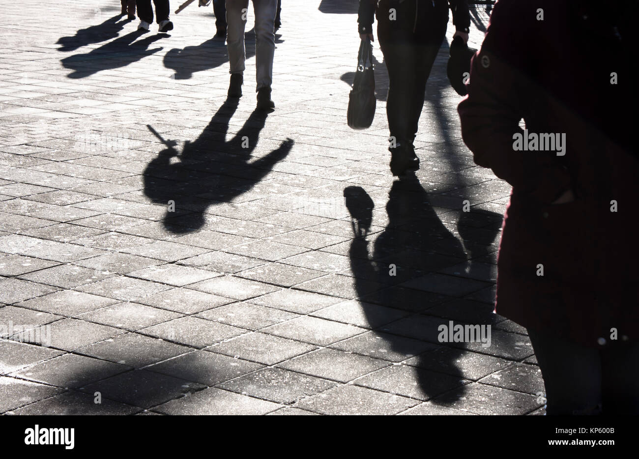 Schatten und Silhouetten von Menschen zu Fuß die Stadt Straße im Winter in Schwarz und Weiß Stockfoto
