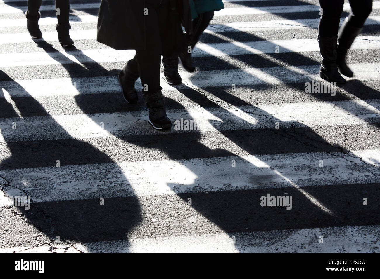 Schatten und Silhouetten, die Überquerung der Straße im Winter in Schwarz und Weiß Stockfoto