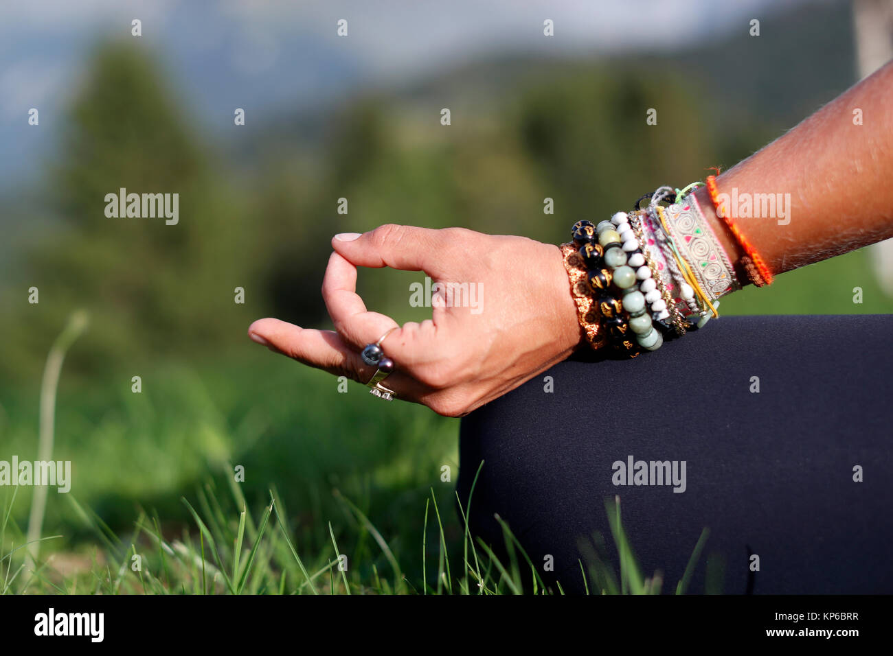 Frau sitzt mit ihren Beinen die Daumen und Hand auf das Knie. Mudra Körperhaltung. Close-up. Frankreich. Stockfoto