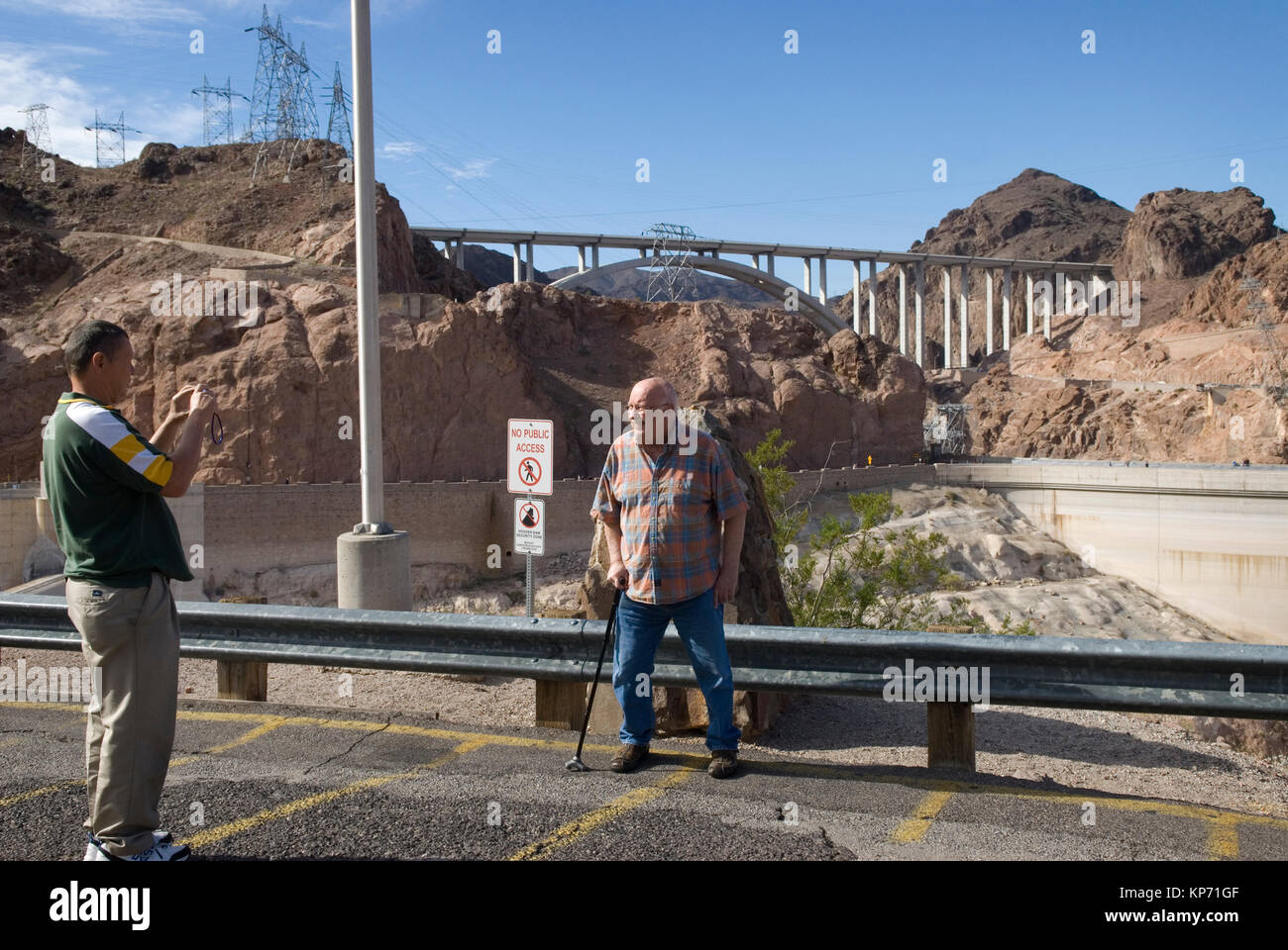 Kaukasischer Mann, der ein Foto eines älteren Mannes auf der Mike O'Callaghan Pat Tillman Memorial Bridge zwischen Arizona und Nevada, USA, einknipst. Stockfoto