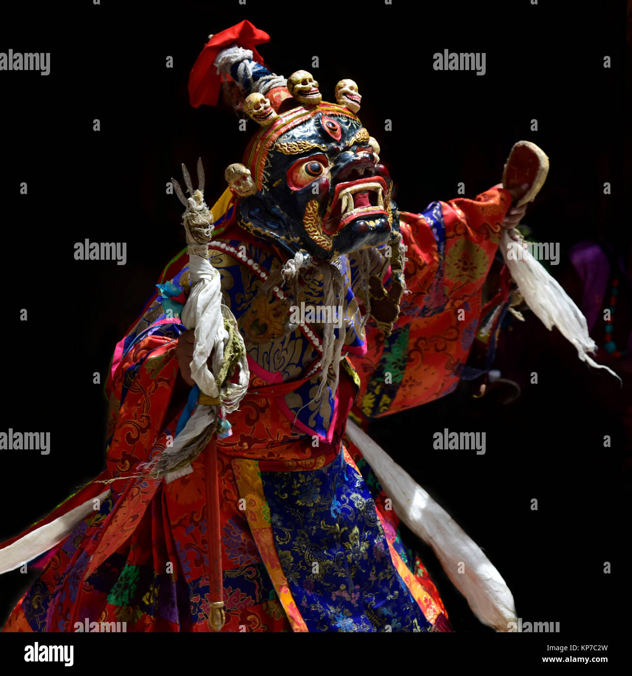 Buddhistischen Lama in der alten Karneval Kostüm und Maske der Palden Lhamo, eine blaue Fläche, eine rote Backe mit weißen Zähne und Verzierungen in Form von kleinen Hu Stockfoto