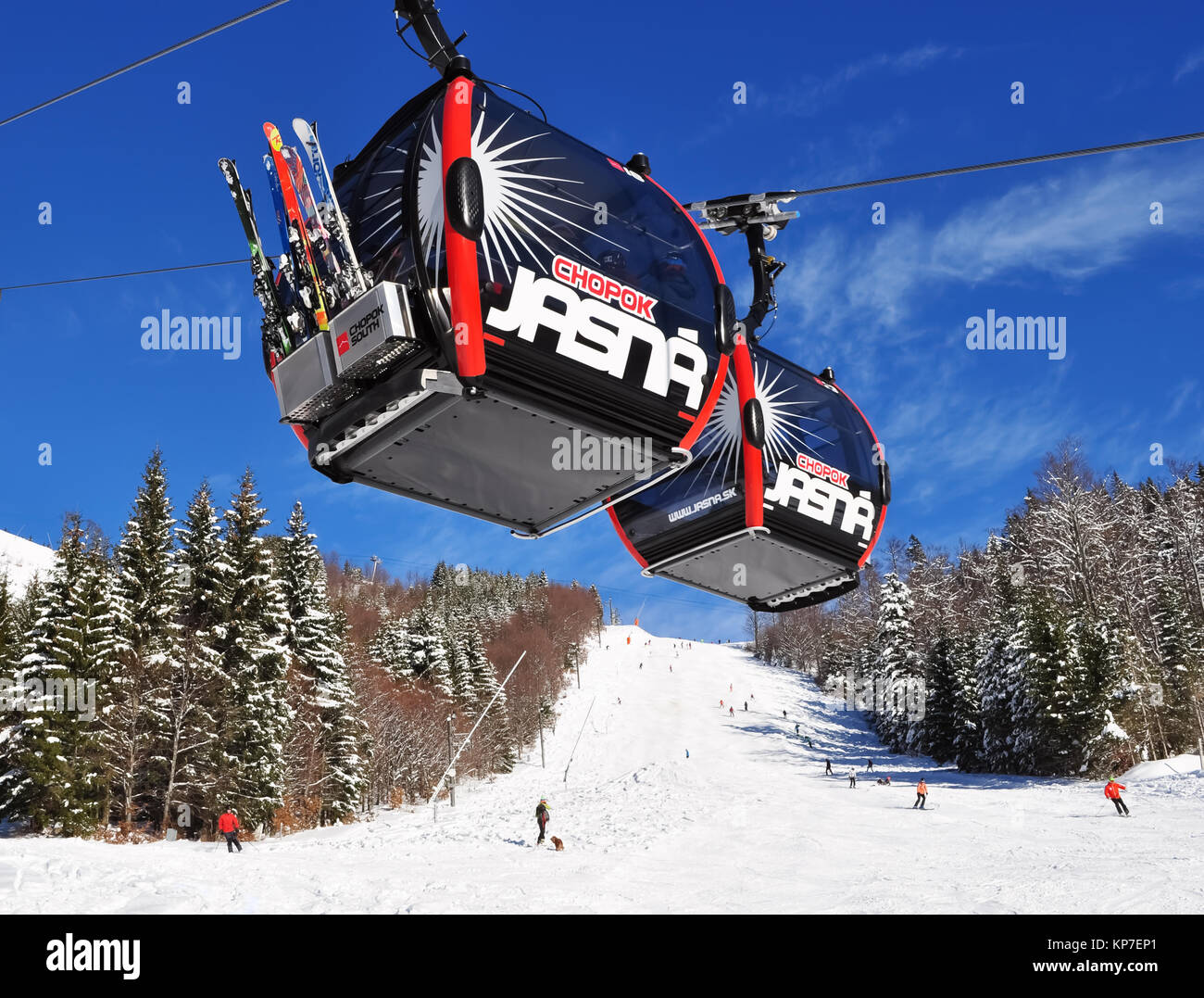 Jasna, Slowakei - Dezember 01, 2017: Zwei Kabinen der Luftseilbahn und Skifahrer auf der Piste des Berges Chopok Süd Seite an einem sonnigen Tag in der Sk Stockfoto