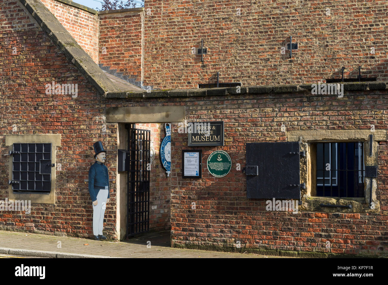 Blick auf den Eingang, vergitterten Fenstern, Rolladen & Schilder im Außenbereich des historischen Gefängnis, jetzt Gefängnis und Polizei Museum - Ripon, North Yorkshire, England, UK. Stockfoto