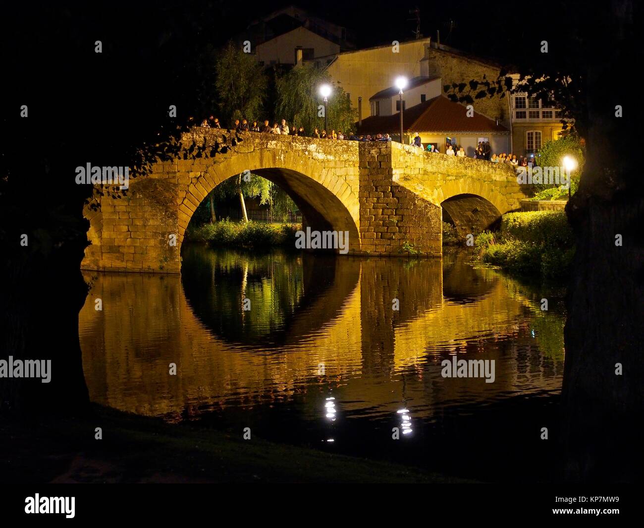 Nachtaufnahme der antiken römischen Brücke in Santiago de Compostela City reflektiert über Cabe Fluss, während der örtlichen Sommer fest. Ribeira Sacra Region Lugo Stockfoto