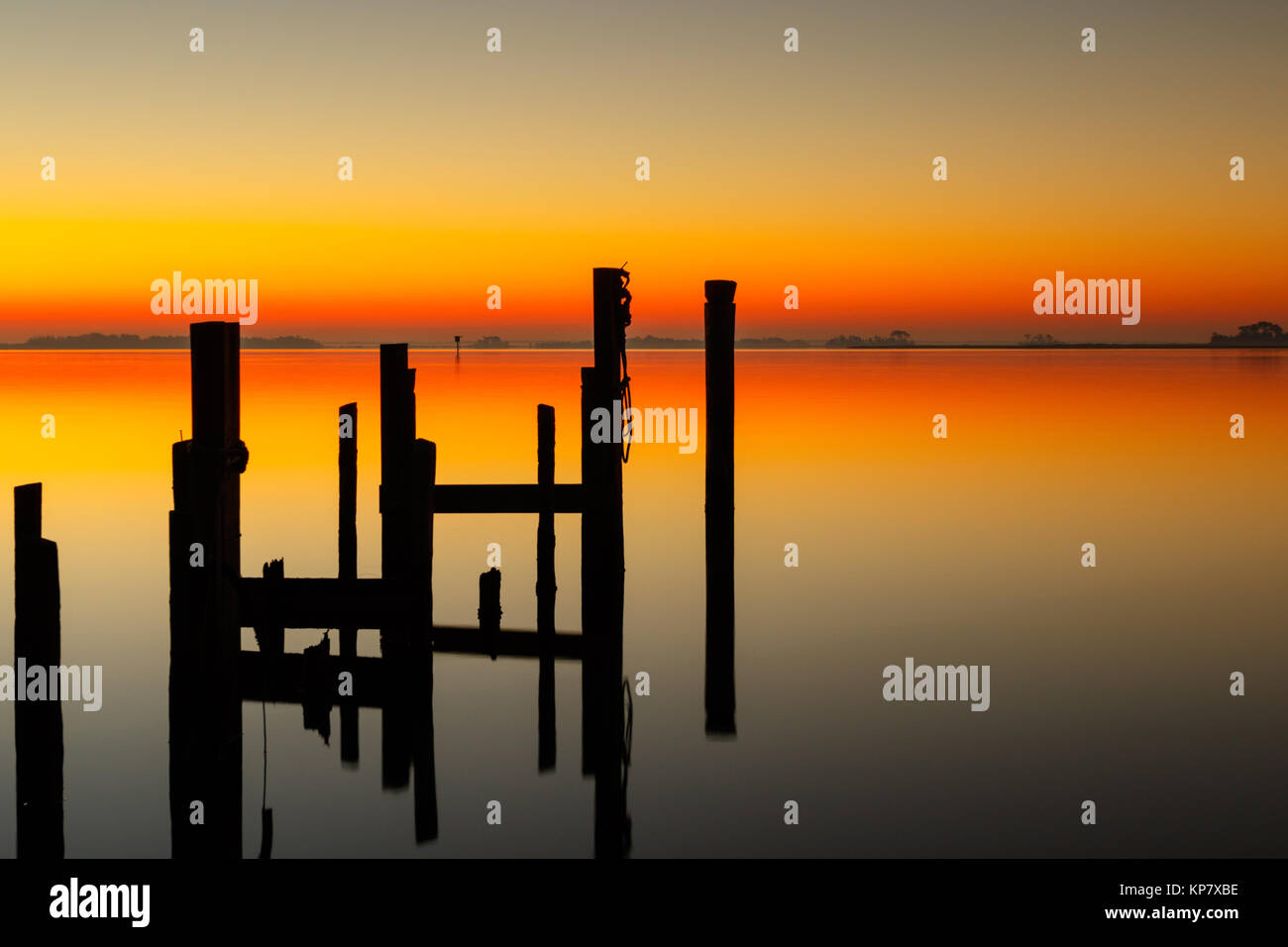 Sonnenaufgang auf Assateague Insel Chincoteague Wildlife Refuge mit Dock und Pylone Silhouette Stockfoto