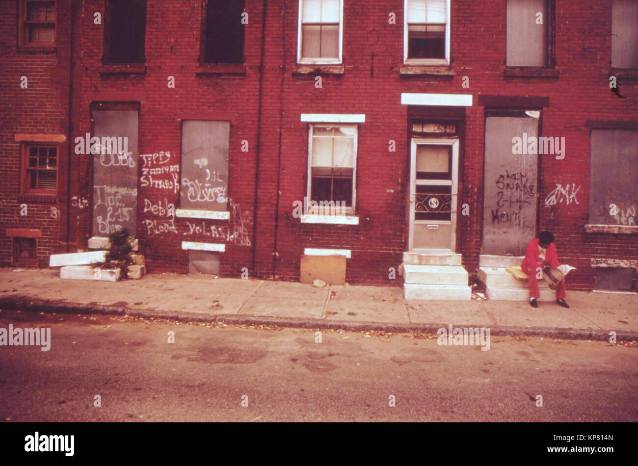 Ein Mann sitzt Lautlos auf beugt einer verlassenen North Philadelphia House, August 1973 Stockfoto