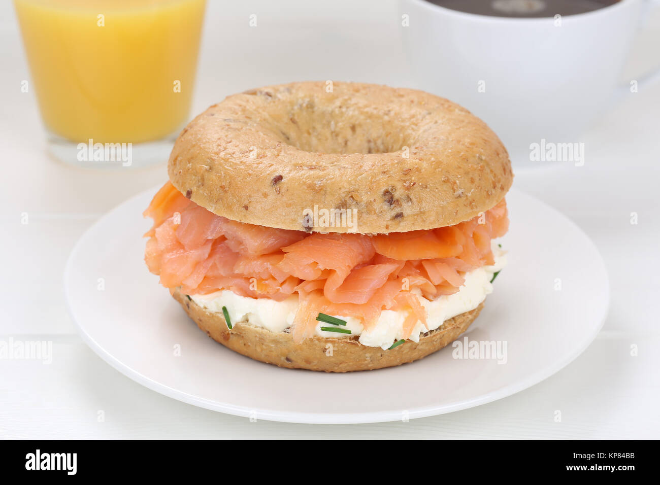 Bagel Brötchen für das Frühstück mit Lachs Fisch, Kaffee und Orangensaft Stockfoto