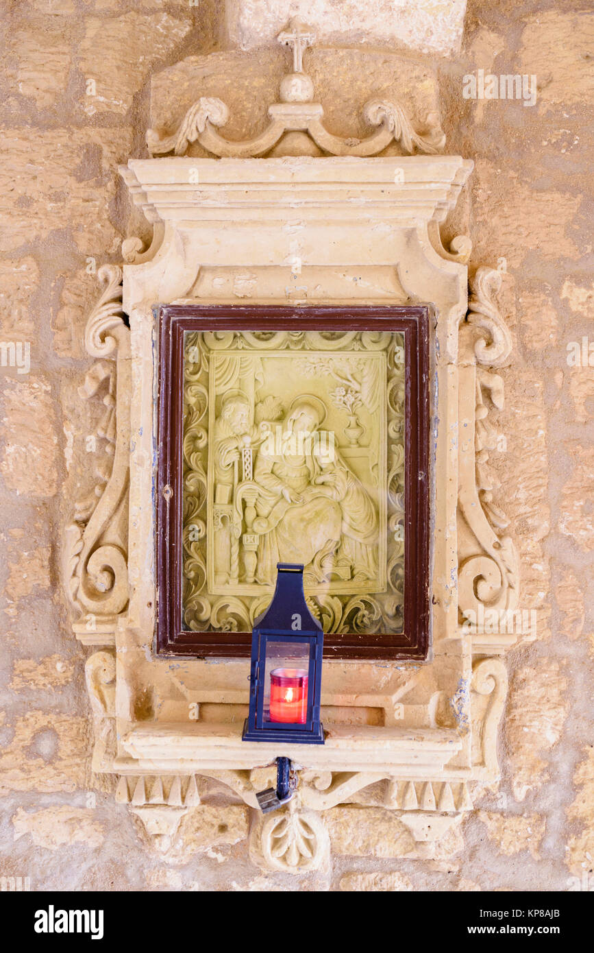 Heilige Carving und Gebet Kerze in eine Wand an der Zitadelle, Victoria, Gozo, Malta. Stockfoto
