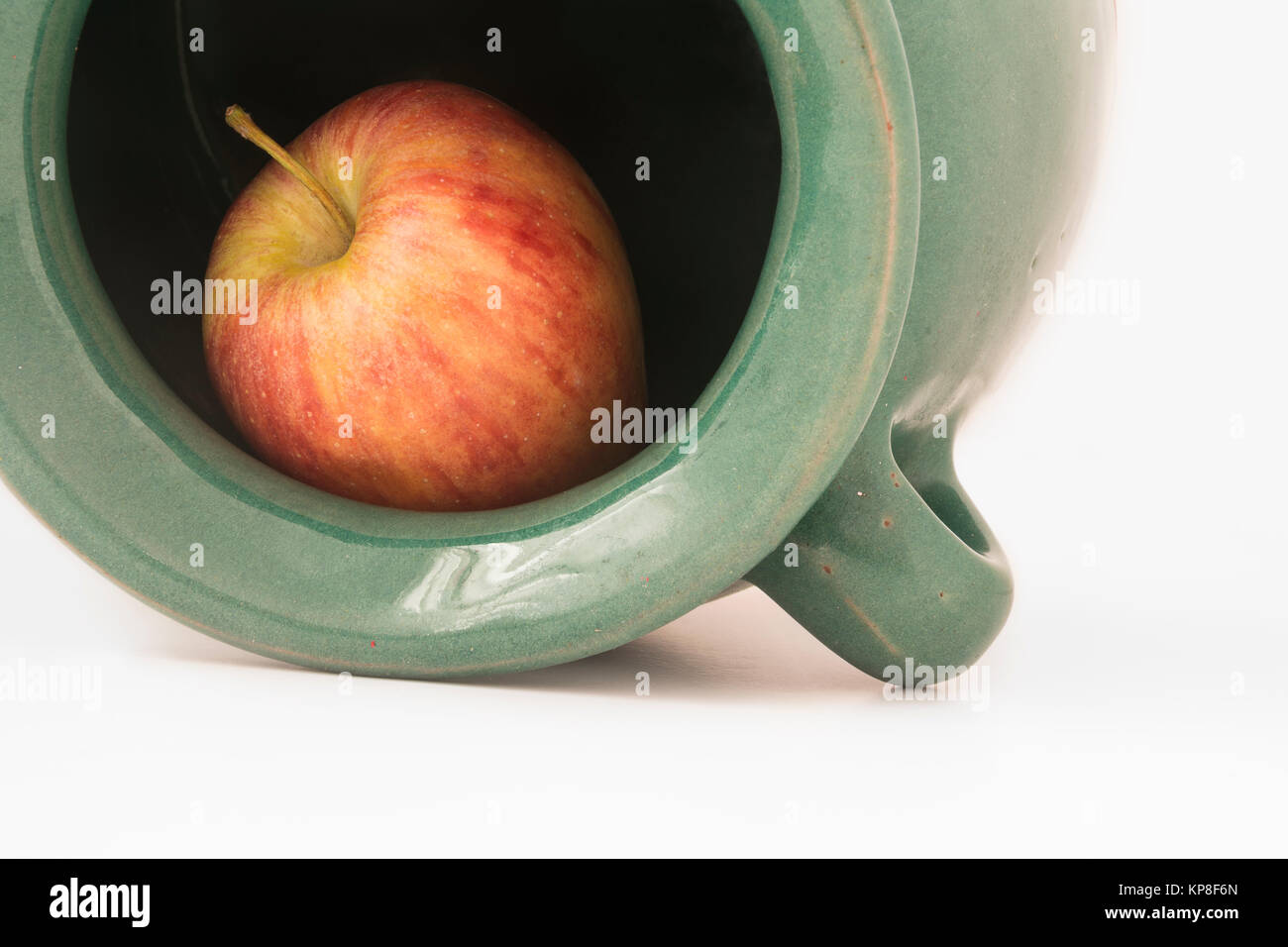 Nahaufnahme Blick auf einen roten Apfel in die grünlich irdenes Gefäß Stockfoto