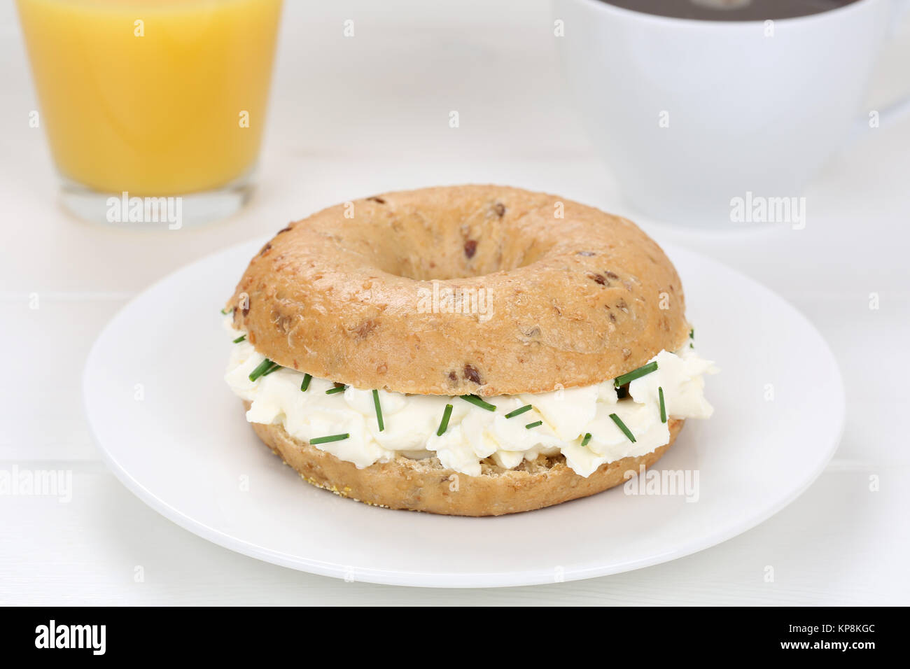 Bagel Brötchen für das Frühstück mit frischem Käse, Kaffee und Orangensaft Stockfoto