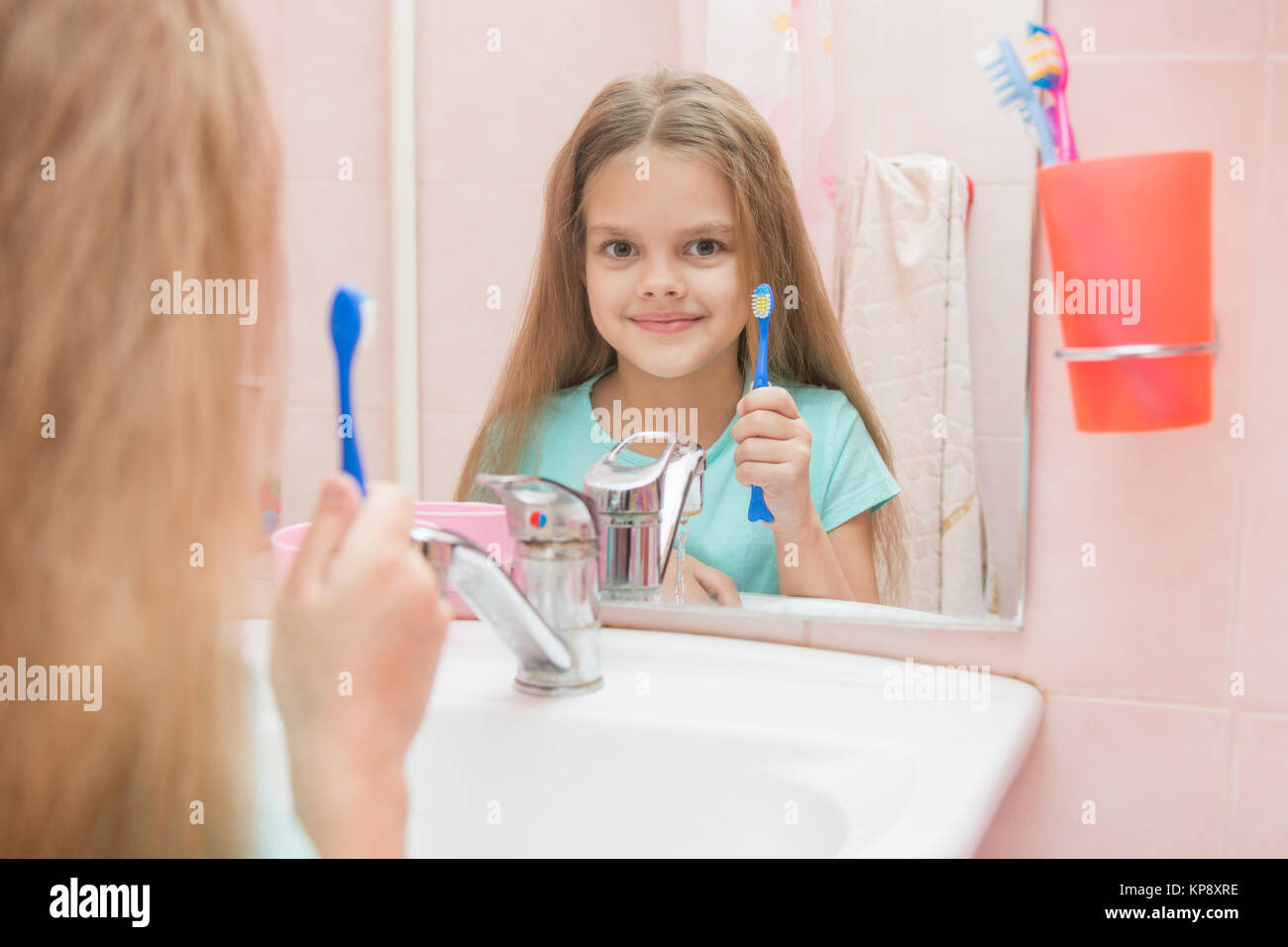 Sechs Jahre altes Mädchen ihren Mund öffnen behandelt Zähne in der Reflexion in einem Spiegel, während im Bad Stockfoto