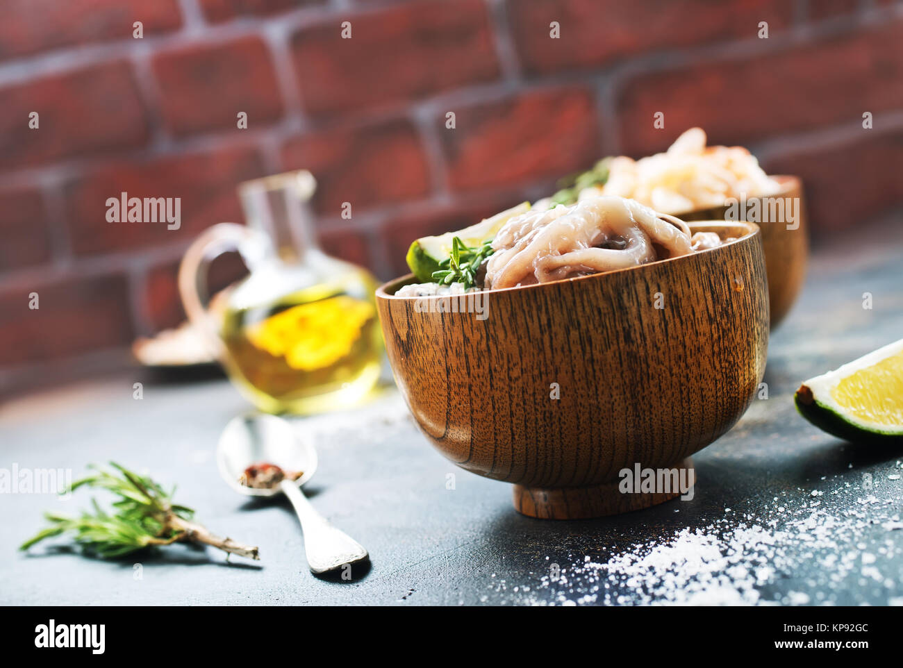 Rohen Tintenfisch in Schüsseln und auf einem Tisch Stockfoto