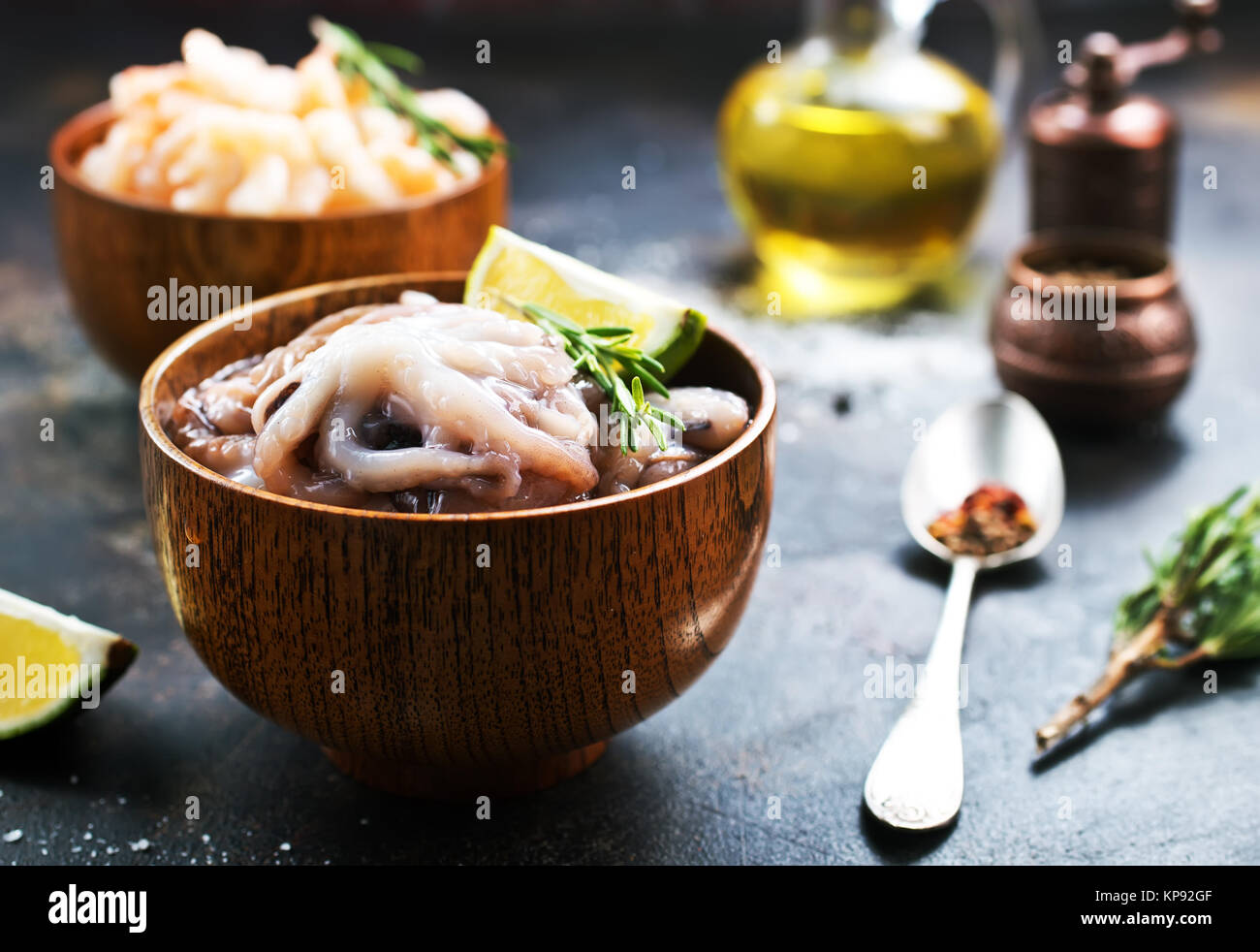 Rohen Tintenfisch in Schüsseln und auf einem Tisch Stockfoto