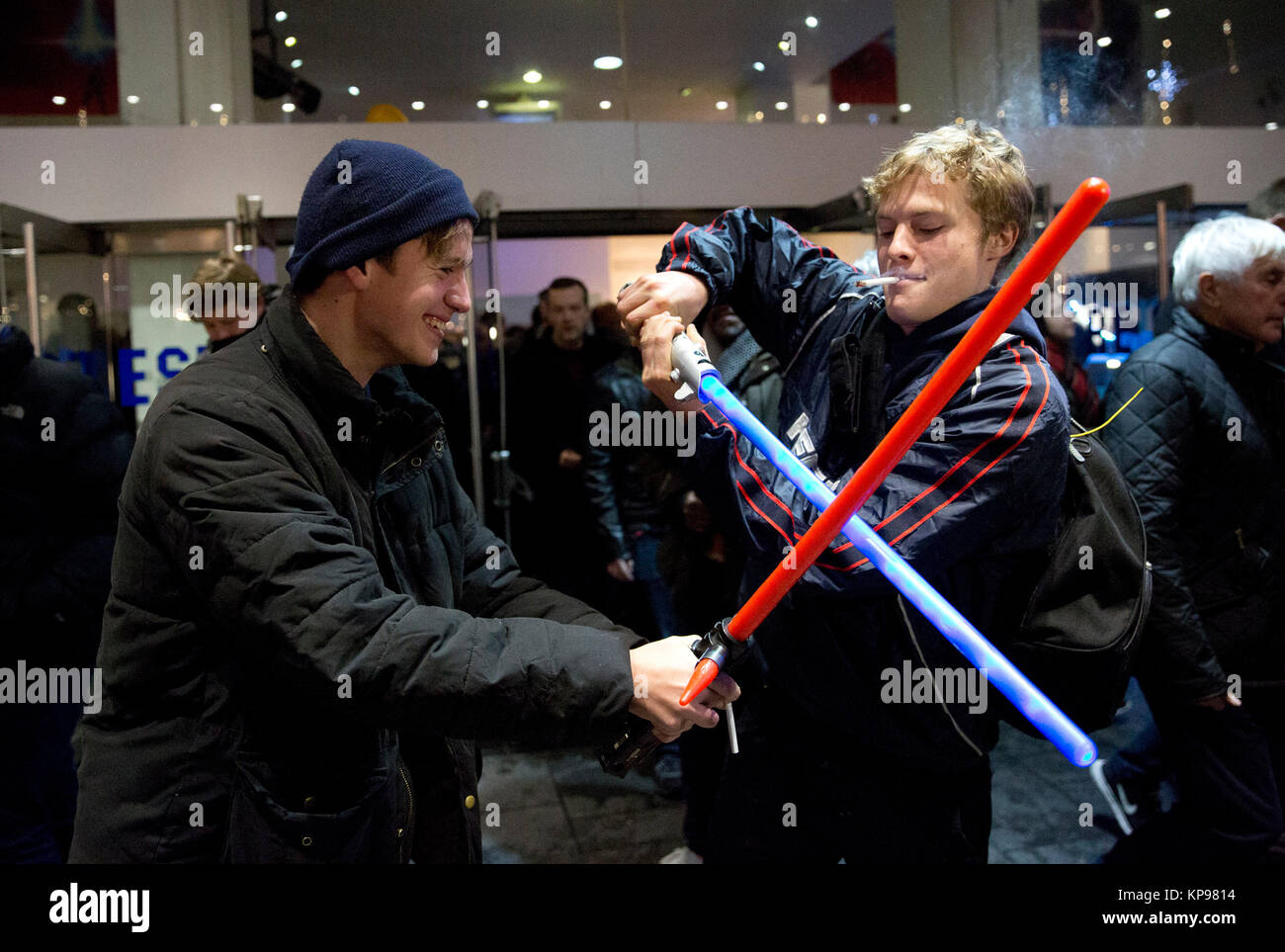 Zwei Fans kämpfen mit ihren Lichtschwertern, wie sie ein Screening von Star Wars: Der letzte Jedi am Leicester Square in London. Stockfoto