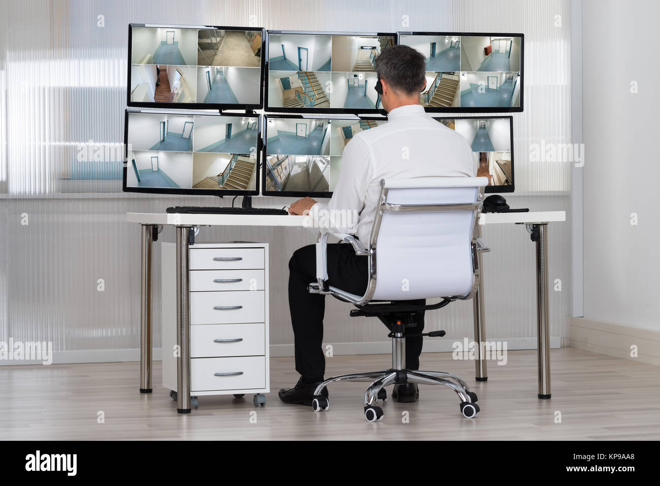 Security System Operator auf CCTV-Aufnahmen am Schreibtisch Stockfoto