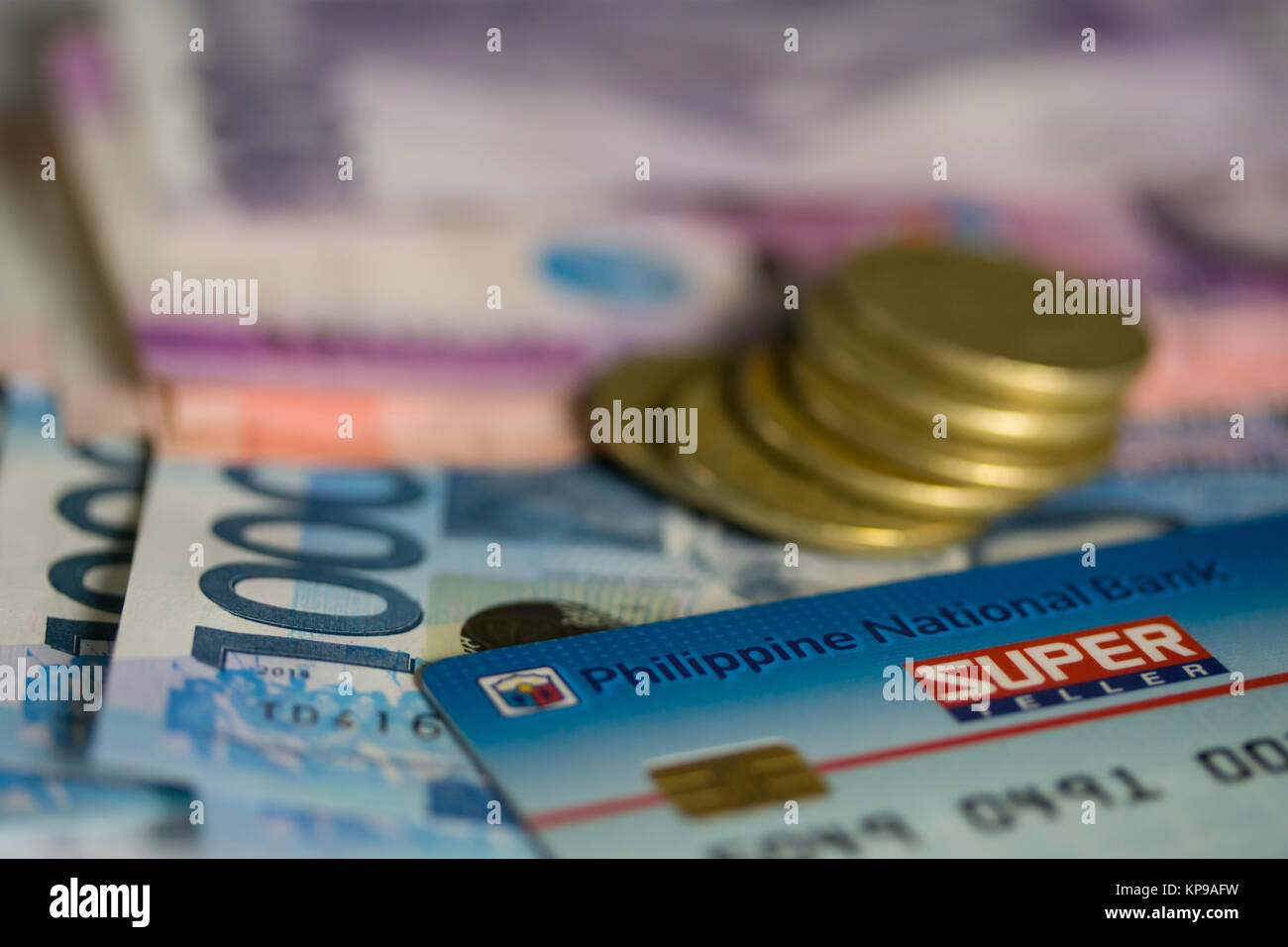 Philippine National Bank ATM Karte mit Peso Banknoten und Münzen Stockfoto