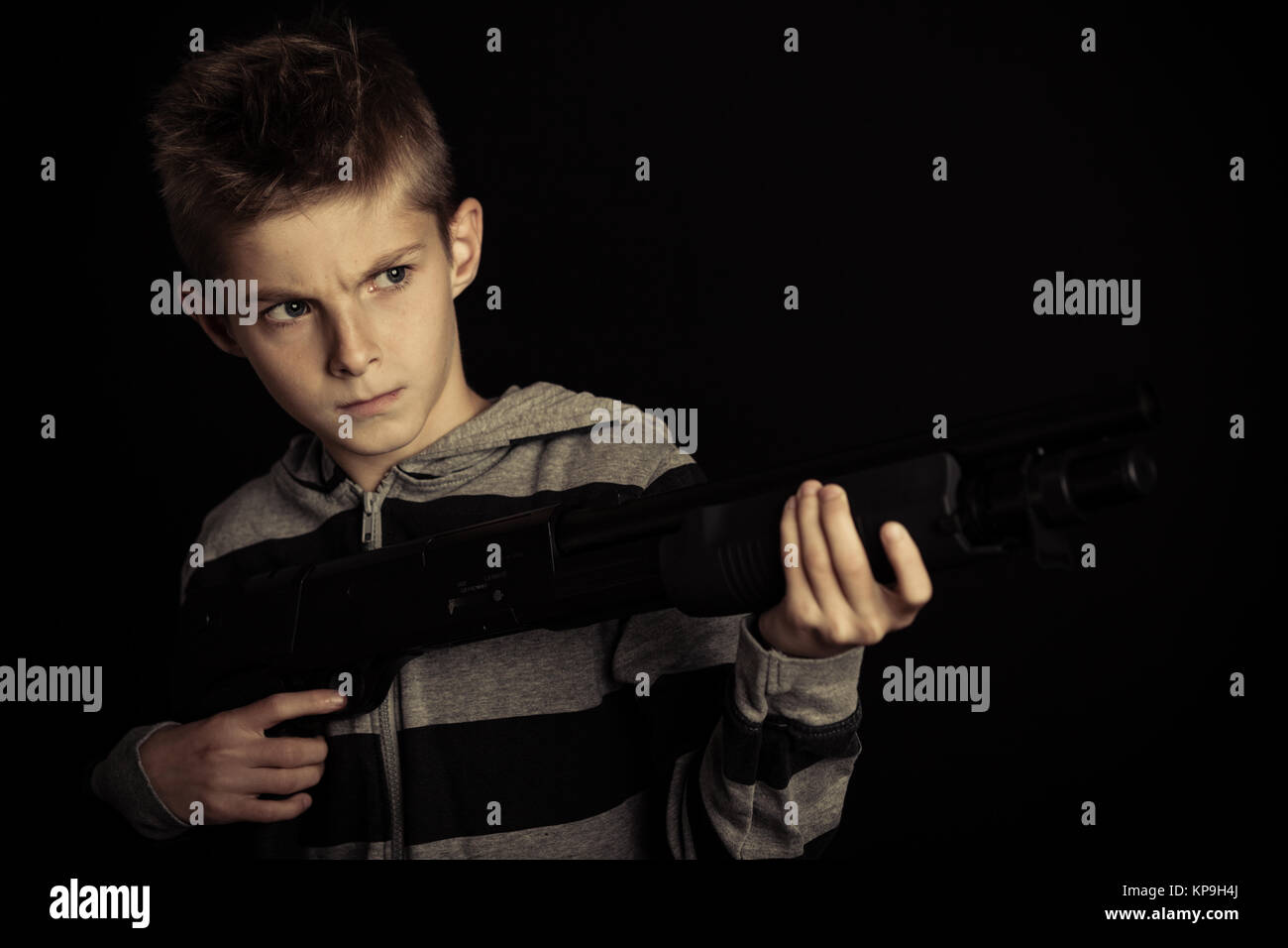 Wütend Junge, der eine Waffe in die Ferne Stockfoto