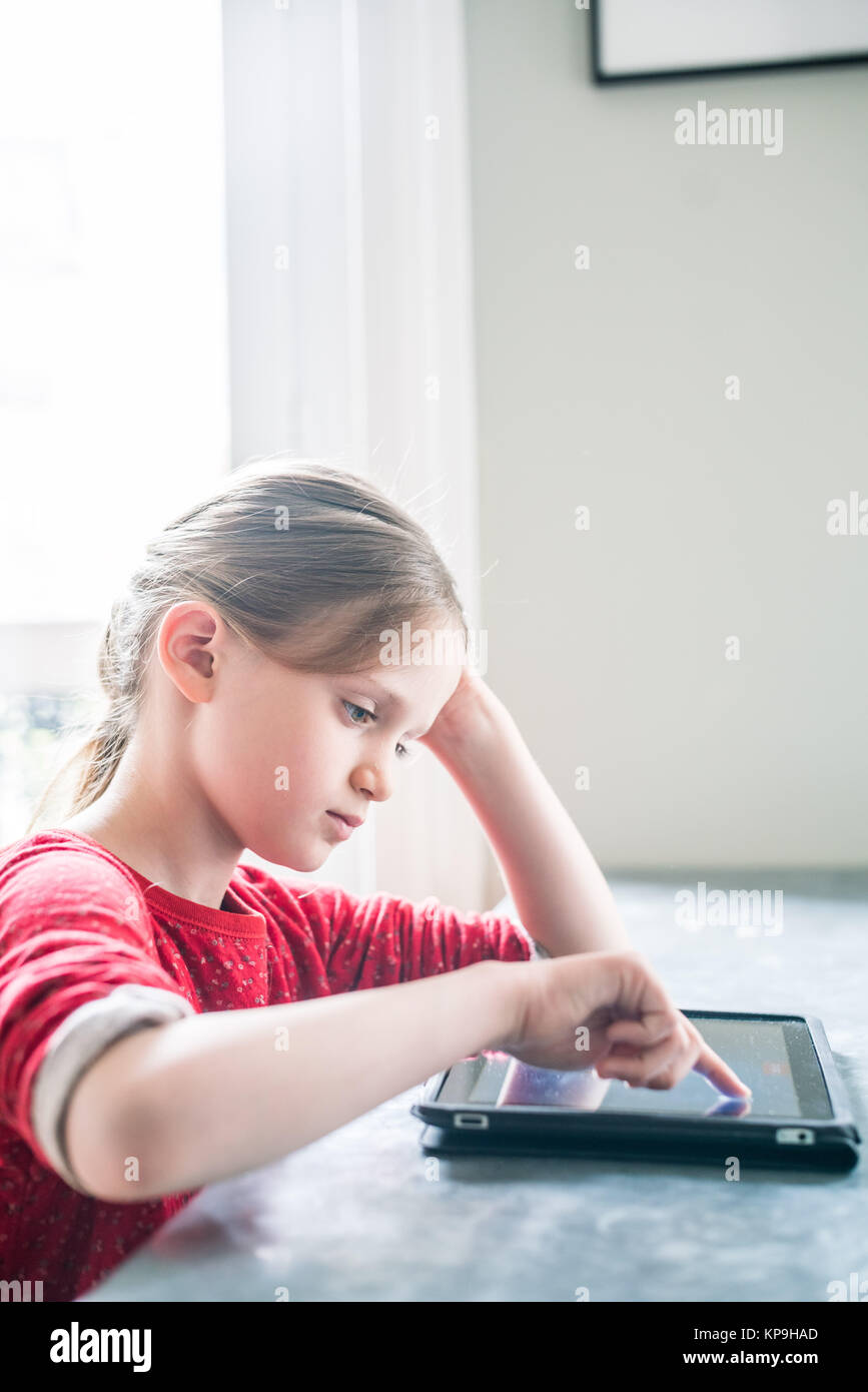 7-jähriges Mädchen mit Tablet-PC. Stockfoto