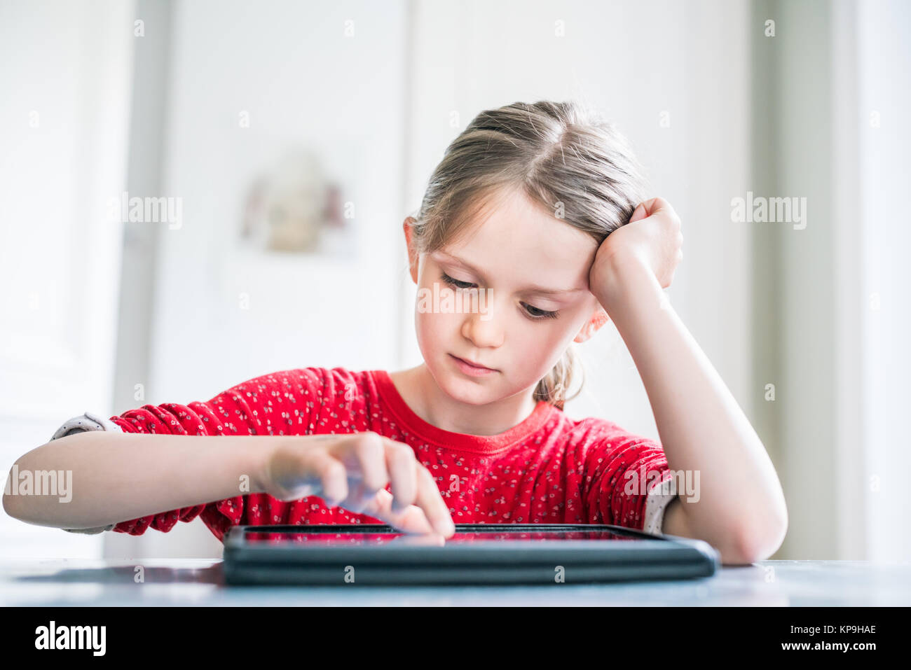 7-jähriges Mädchen mit Tablet-PC. Stockfoto