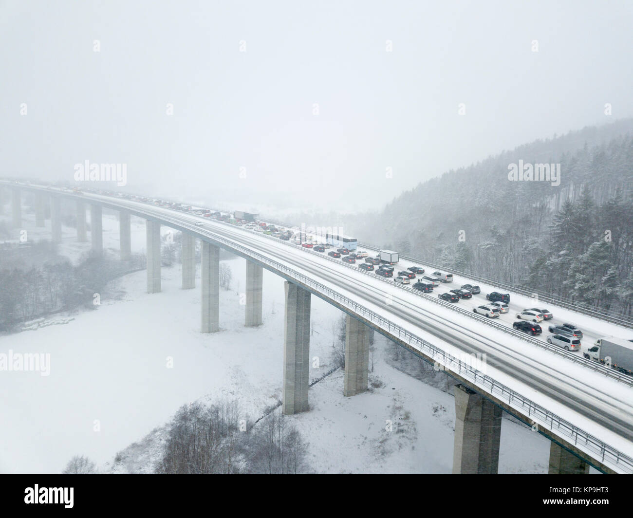 Luftaufnahme über eine Autobahnbrücke bei starkem Schneefall im Winter Stockfoto