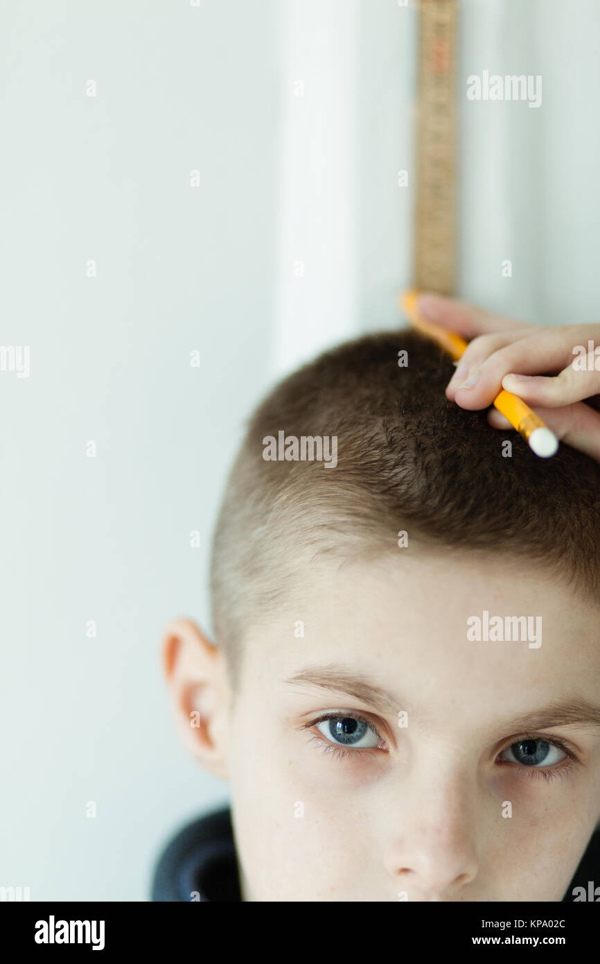 Junge Holding Bleistift auf seinem Kopf zu prüfen Stockfoto