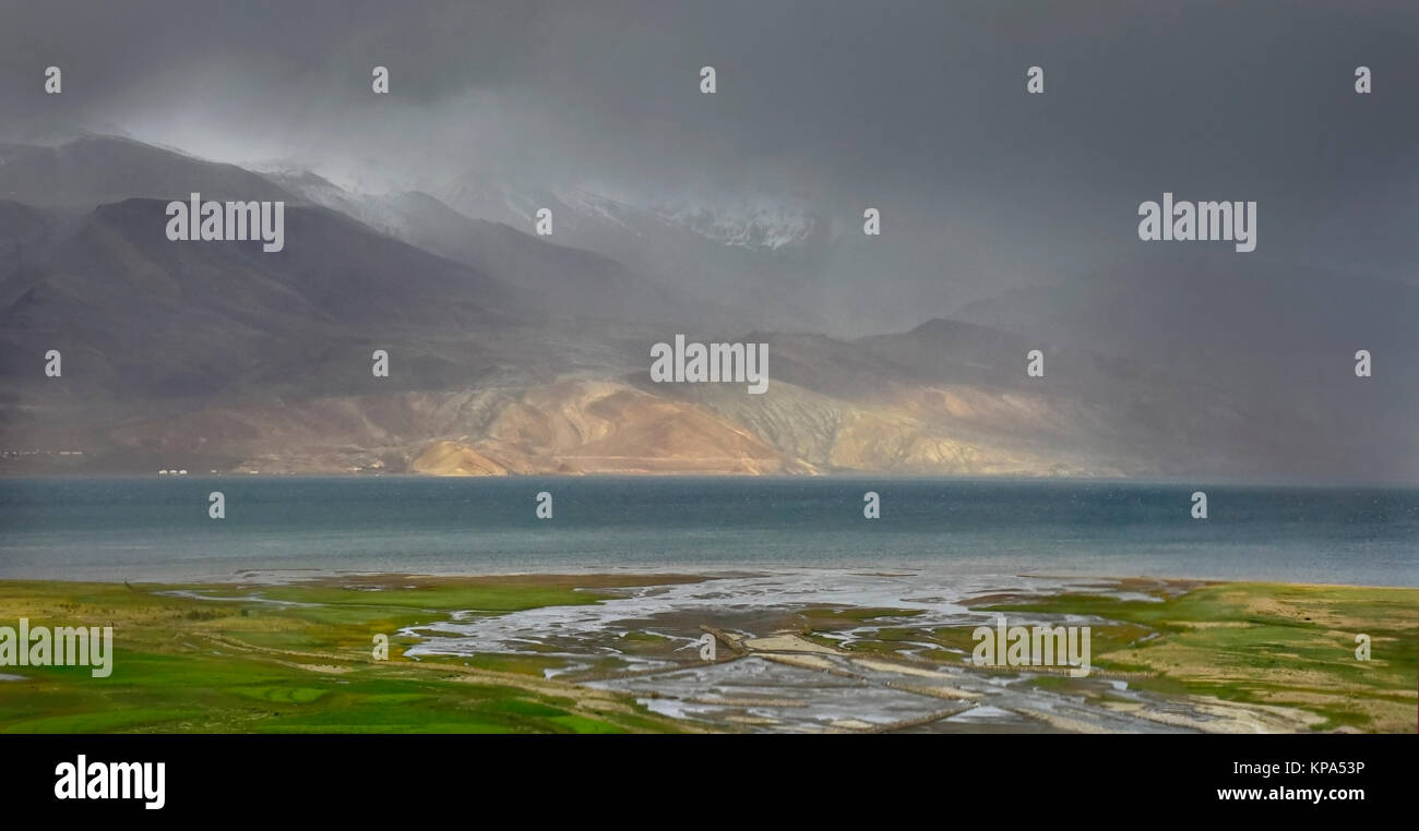 Gewitter am See Tso Moriri: Blue Lake Oberfläche, Green river floodplain, Berge sind in Sturm, Wolken und Nebel, Ladakh, Indien verloren. Stockfoto