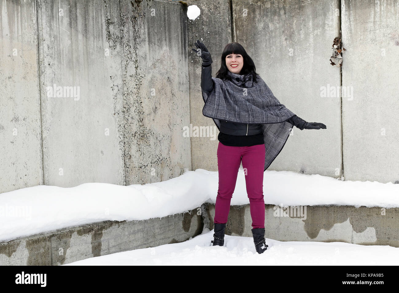 Spaß im Schnee - EINE junge Frau wirft einen Schneeball Stockfoto