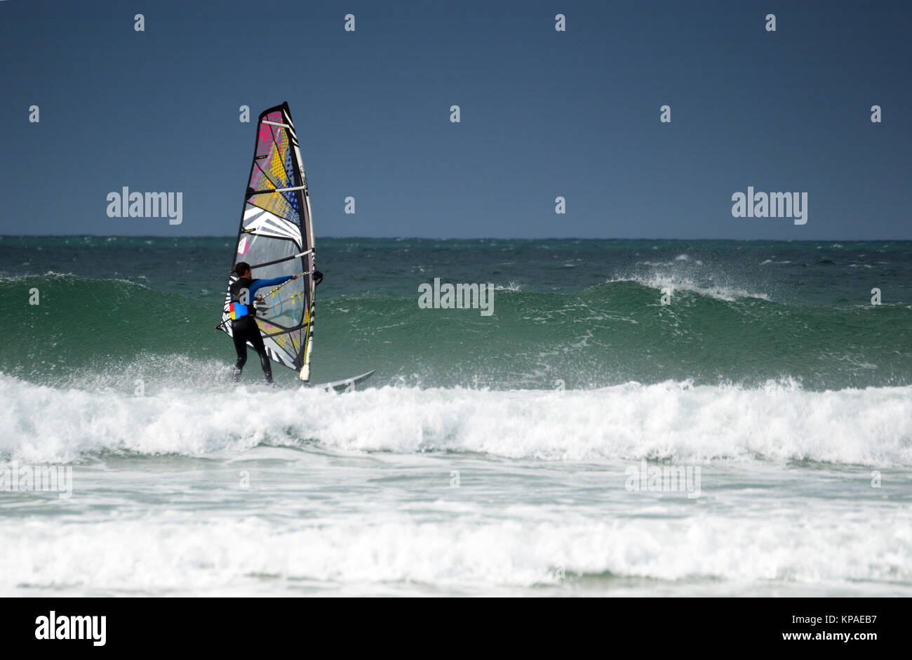 Man windsurfen Wellen in Gwithian, Cornwall, UK. Stockfoto