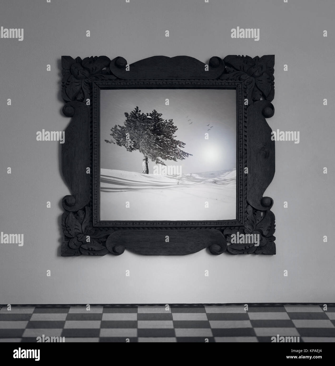 Detail aus einem Rahmen, Spiegel an der Wand mit einem Bild von einem Baum auf dem Schnee in Schwarz und Weiß Stockfoto
