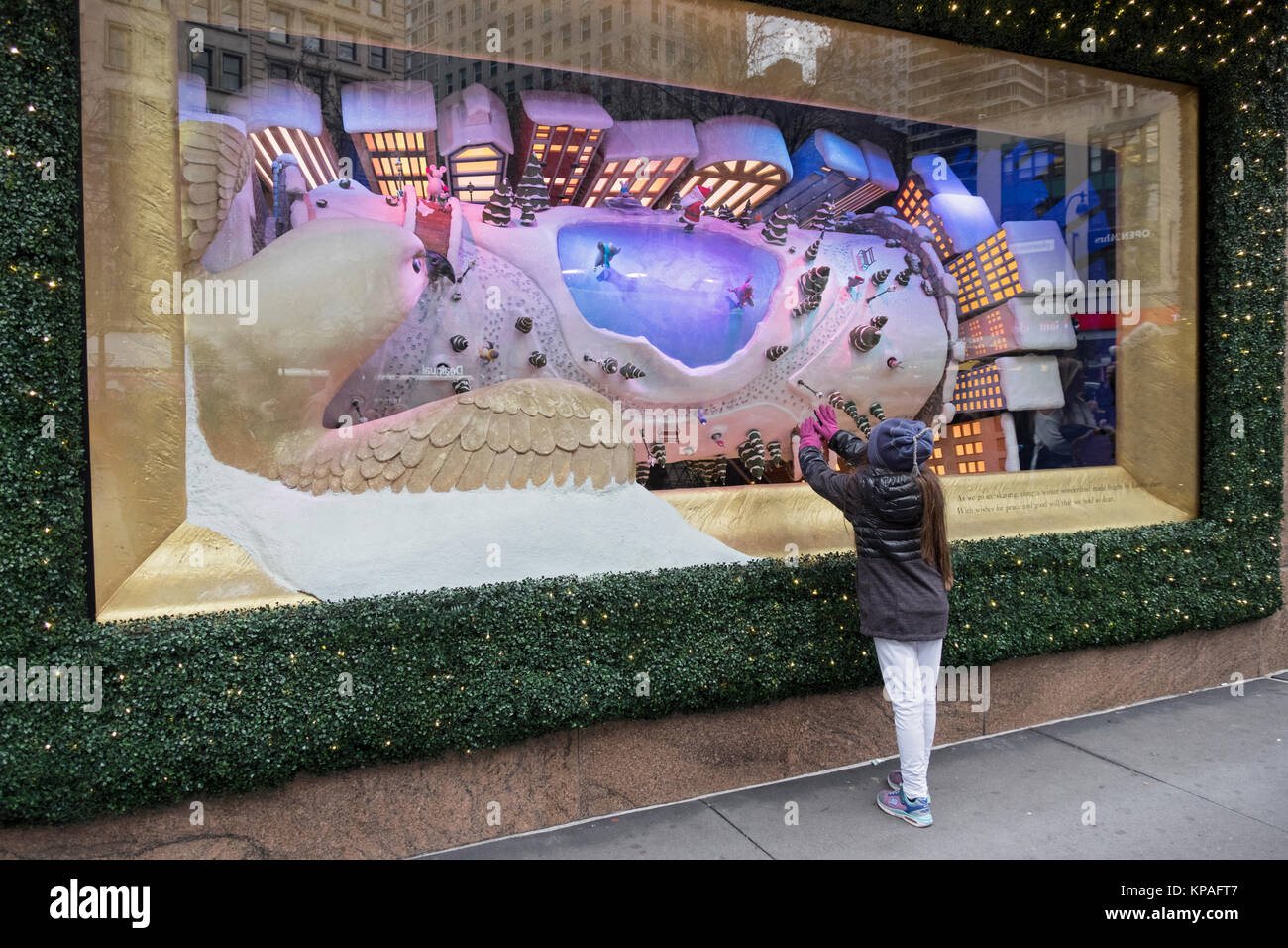 Ein nicht identifizierter junge Mädchen berührt die Fenster eines Macy Weihnachten Anzeige am Herald Square in Manhattan, New York City. Stockfoto