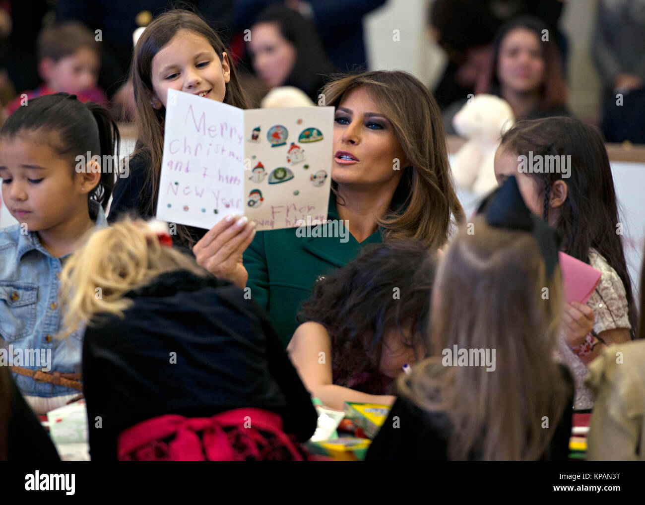 Washington, Vereinigte Staaten von Amerika. 13 Dez, 2017. First Lady der USA Melania Trump Bewertungen eine Weihnachtskarte von einem Kind während der jährlichen Marine Corps Stiftung Holzspielzeug für Tots bei Joint Base Anacostia-Bolling Dezember 13, 2017 in Washington, DC. Die erste Dame folgte die langjährige Tradition der anderen Tannen Damen in helfenden Kindern Karten, sortiert Spielzeug, und der Nächstenliebe, die Veranstaltung zu Ehren. Credit: Planetpix/Alamy leben Nachrichten Stockfoto