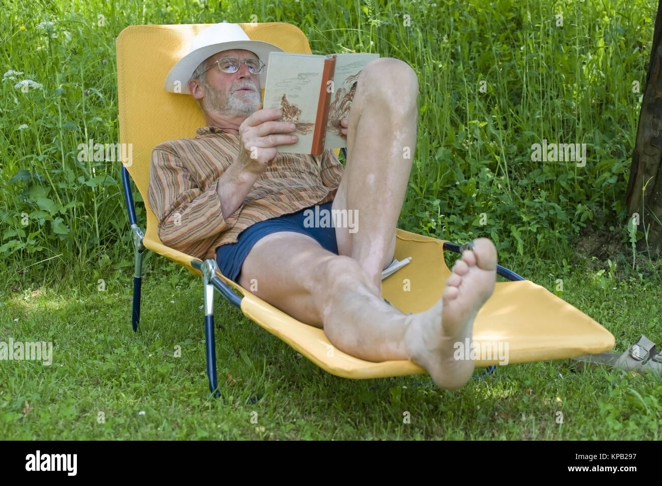 Model Release, Pensionist, 65 +, so Auf Liegestuhl Im Garten Und liest Ein Buch - Rentner auf einem Liegestuhl liegen und ein Buch zu lesen Stockfoto
