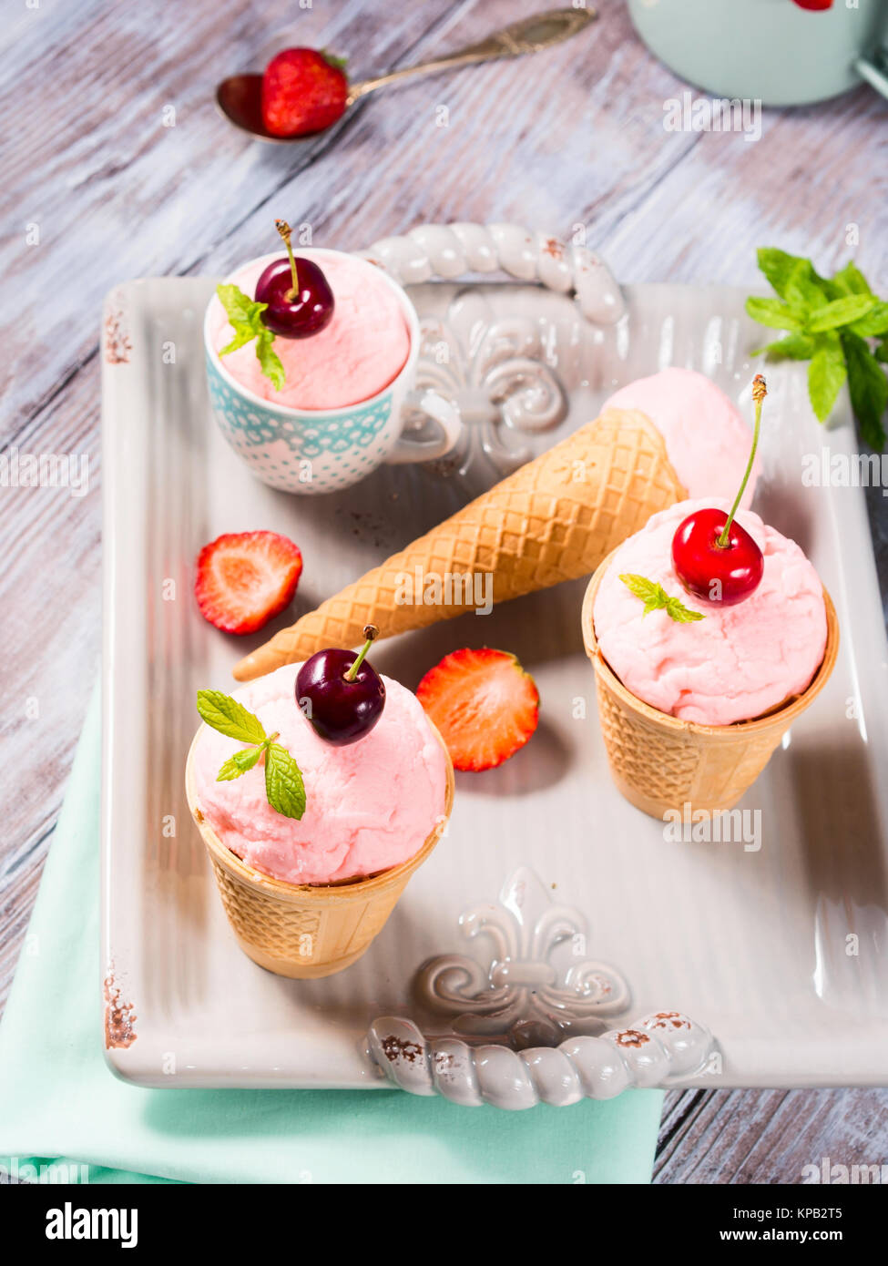 Hausgemachte Erdbeere und Kirsche Eis in der Waffel Lagerringe und -kegel auf einem keramischen Fach Vintage Stimmung serviert. Stockfoto