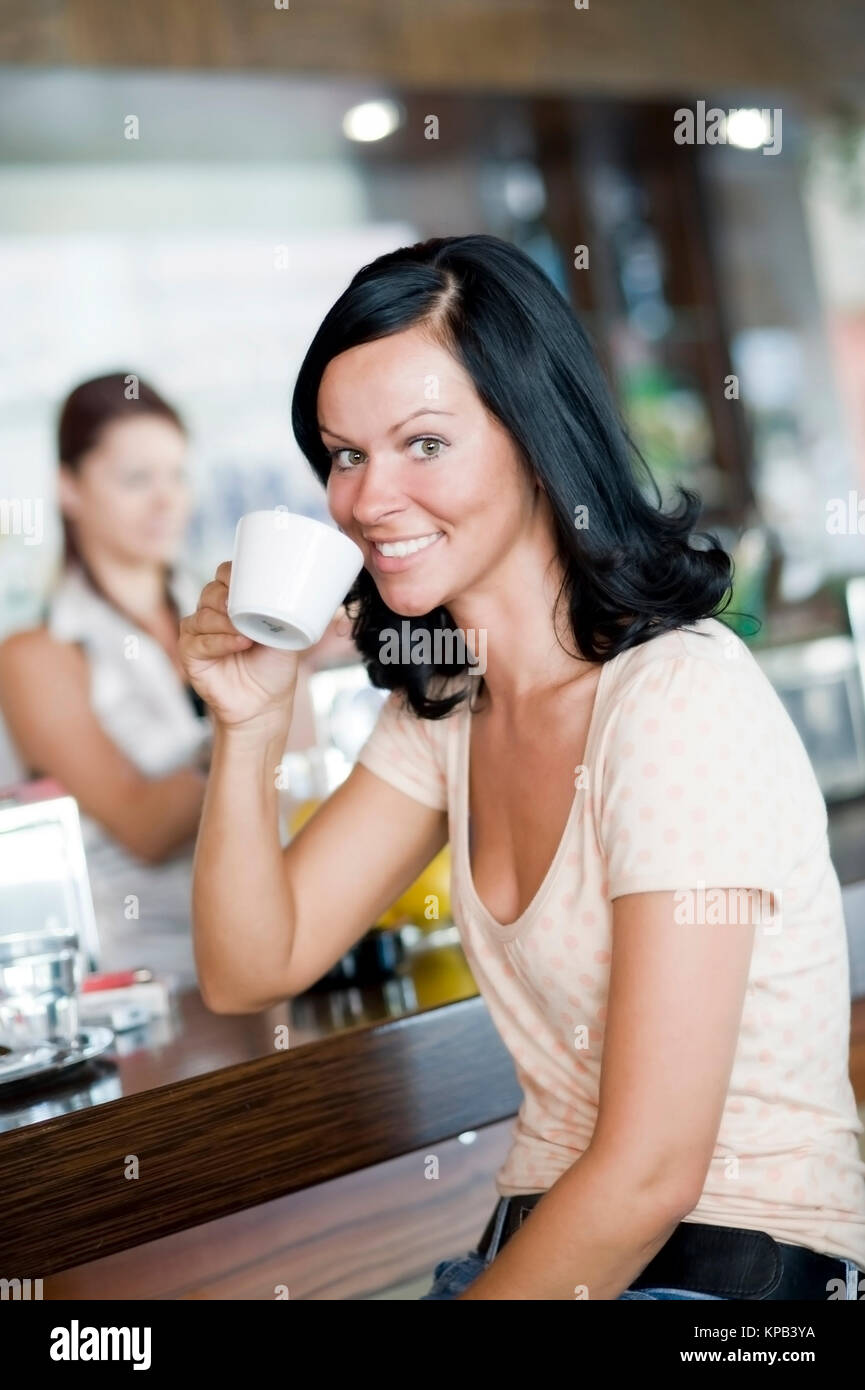 Model Release, Junge Frau Sitzt Im Kaffeehaus ein der Theke Und entschied Kaffee - junge Frau in Cafeteria trinkt Kaffee Stockfoto