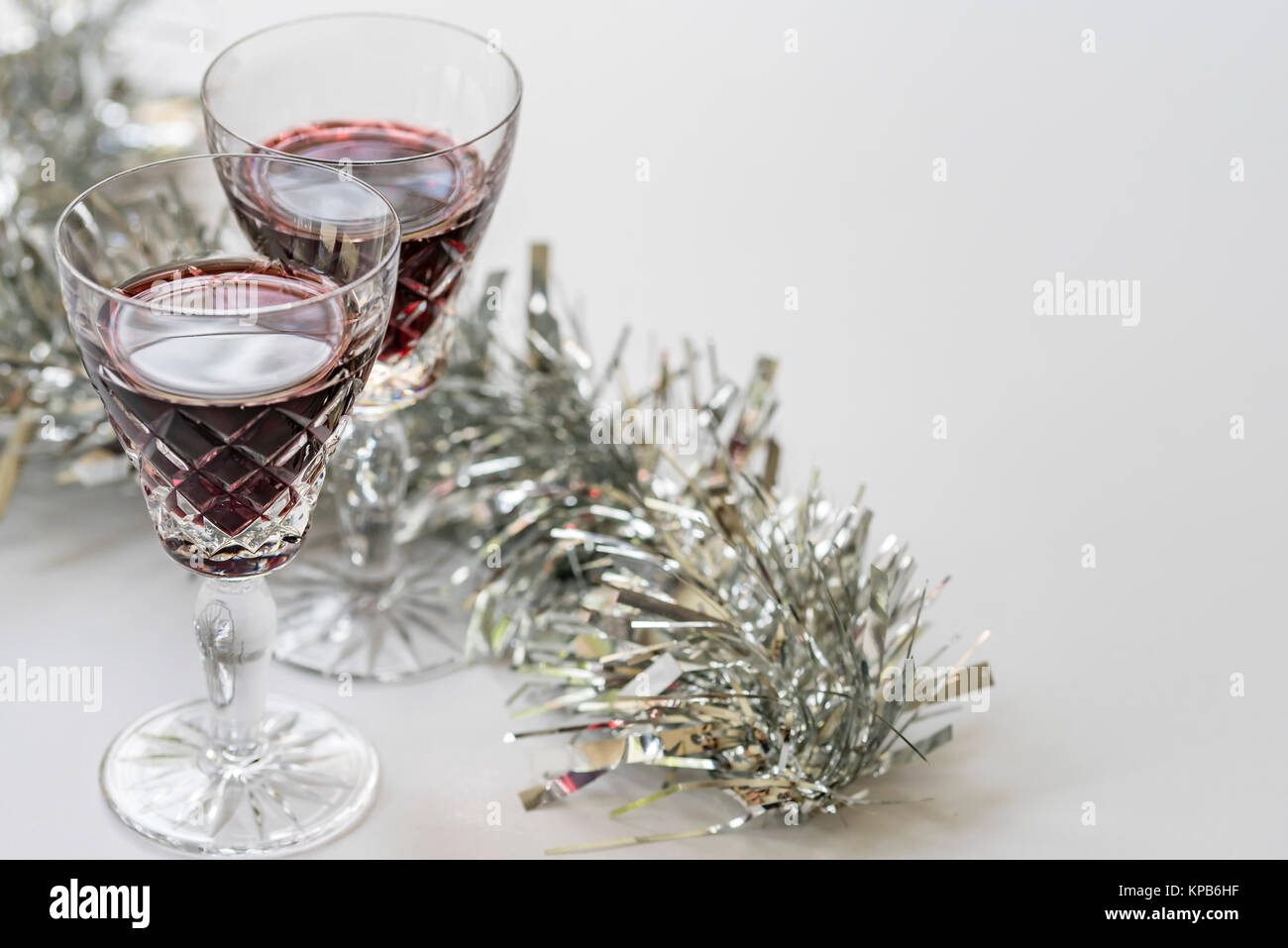 Gläser Rotwein, silber auf weißem Hintergrund, Ansicht von oben. Weihnachten festliche Thema, Weingläser, silber Lametta glänzt, Raum für Text. Stockfoto