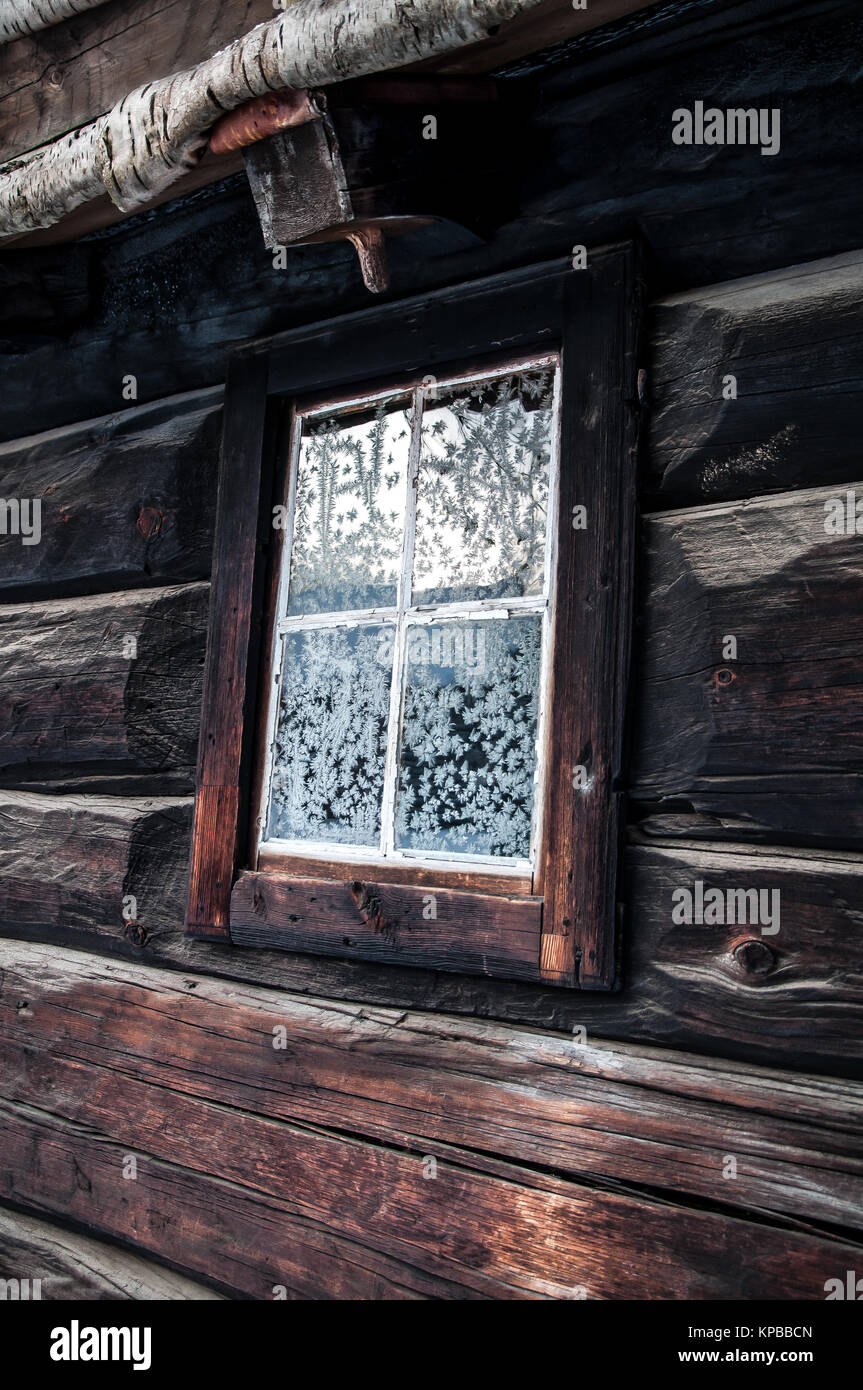 Ein altes Haus im Winter mit snowcrystals auf dem Fenster. Stockfoto
