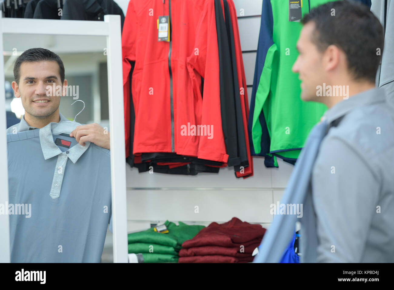 Mann, ein T-Shirt auf dem Versuchen, Stockfoto