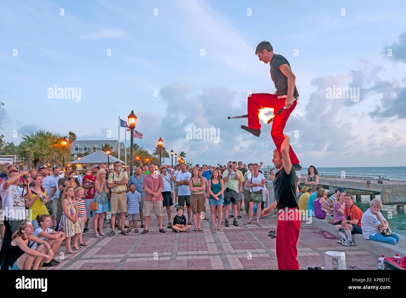 Akrobatischen Gaukler mit Feuer schlagstöcke Sonnenuntergangfeier Key West Florida Stockfoto