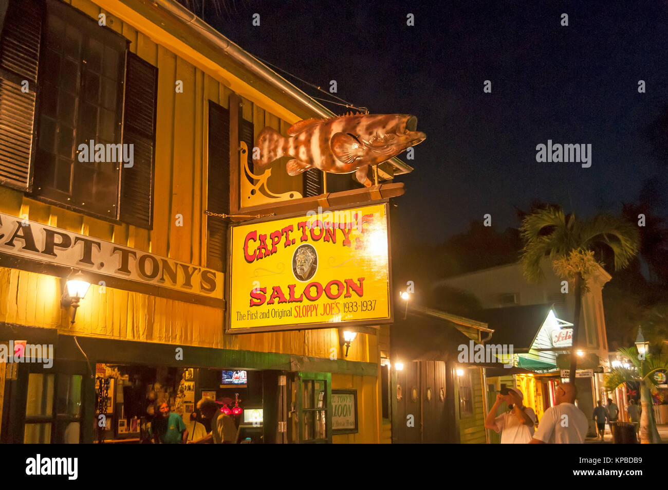 Captain Tony's Saloon auf Greene Street ist eine touristische Attraktion und Celebrity hangout mit einem jewfish in seinen gelben Zeichen in der Nacht, Key West Florida Stockfoto