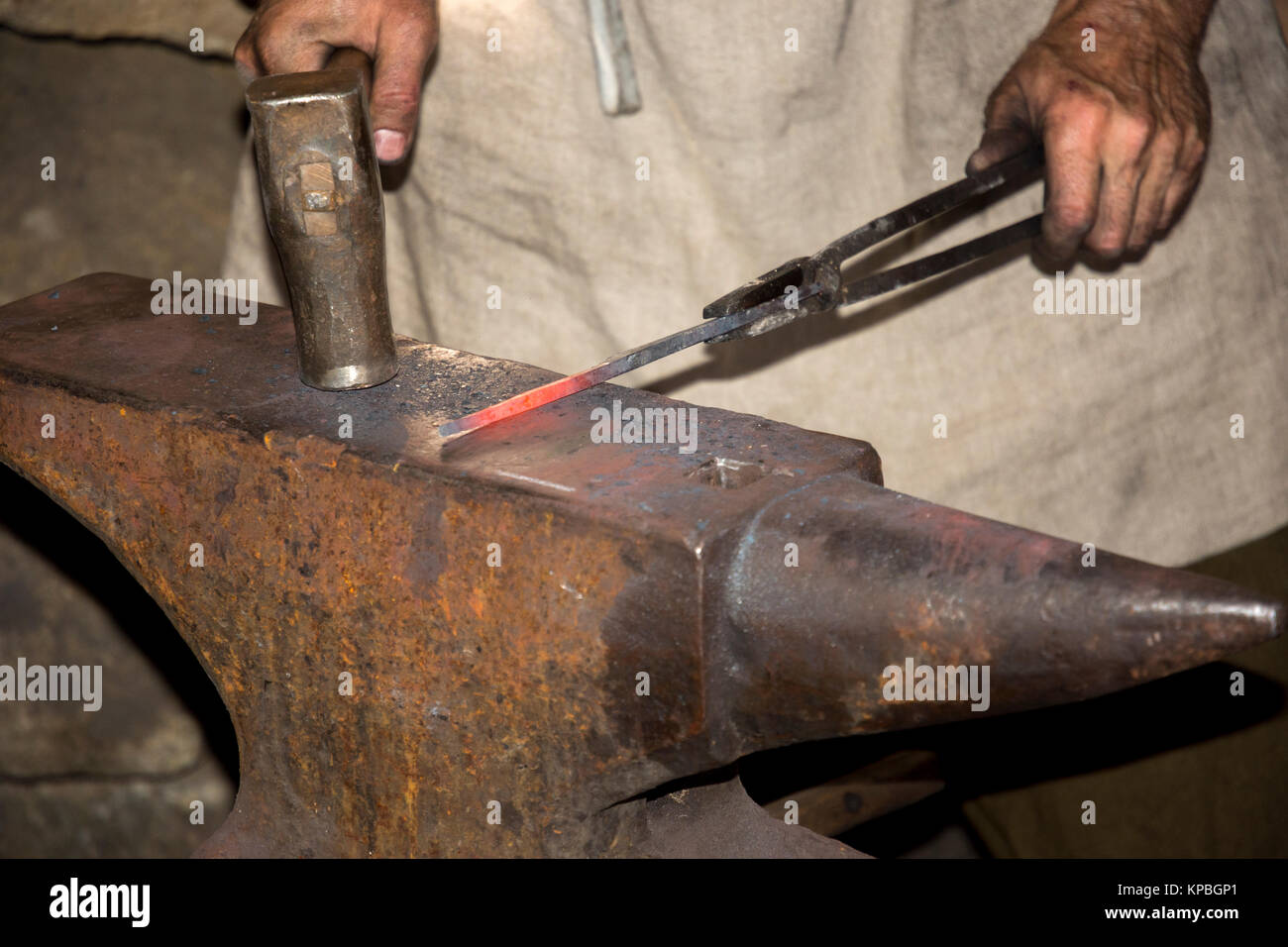 Schmied, während Er schmiedet ein Schwert durch das Schlagen der glühende Metall auf einen Amboss Stockfoto