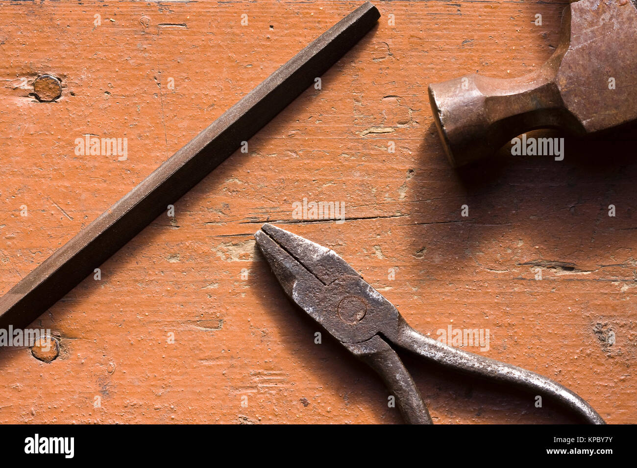 Alte verrostete Zangen, Datei- und Hammer auf der Workbench Stockfoto