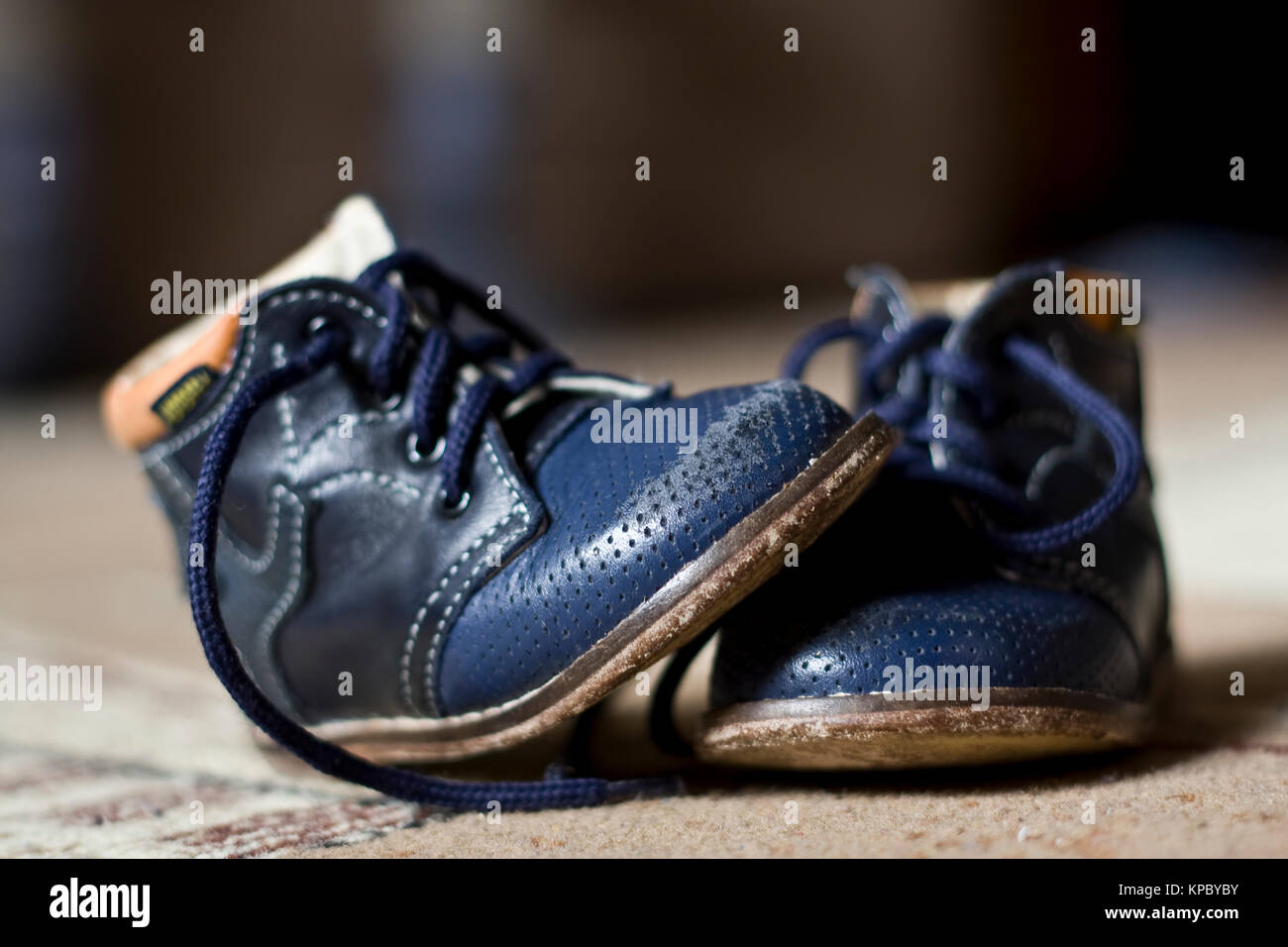 Die alten blauen getragen Kinder Stiefel auf einem Teppich Stockfoto