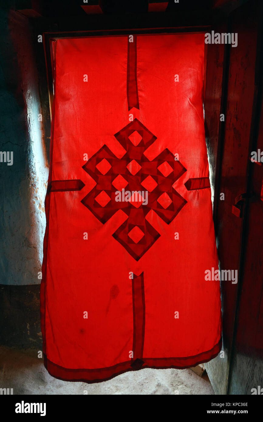 Rote Tür Vorhang mit der endlose Knoten, eine der acht Glücksverheißenden tibetisch-buddhistischen Symbole, Lo Mantang, Upper Mustang, Nepal. Stockfoto