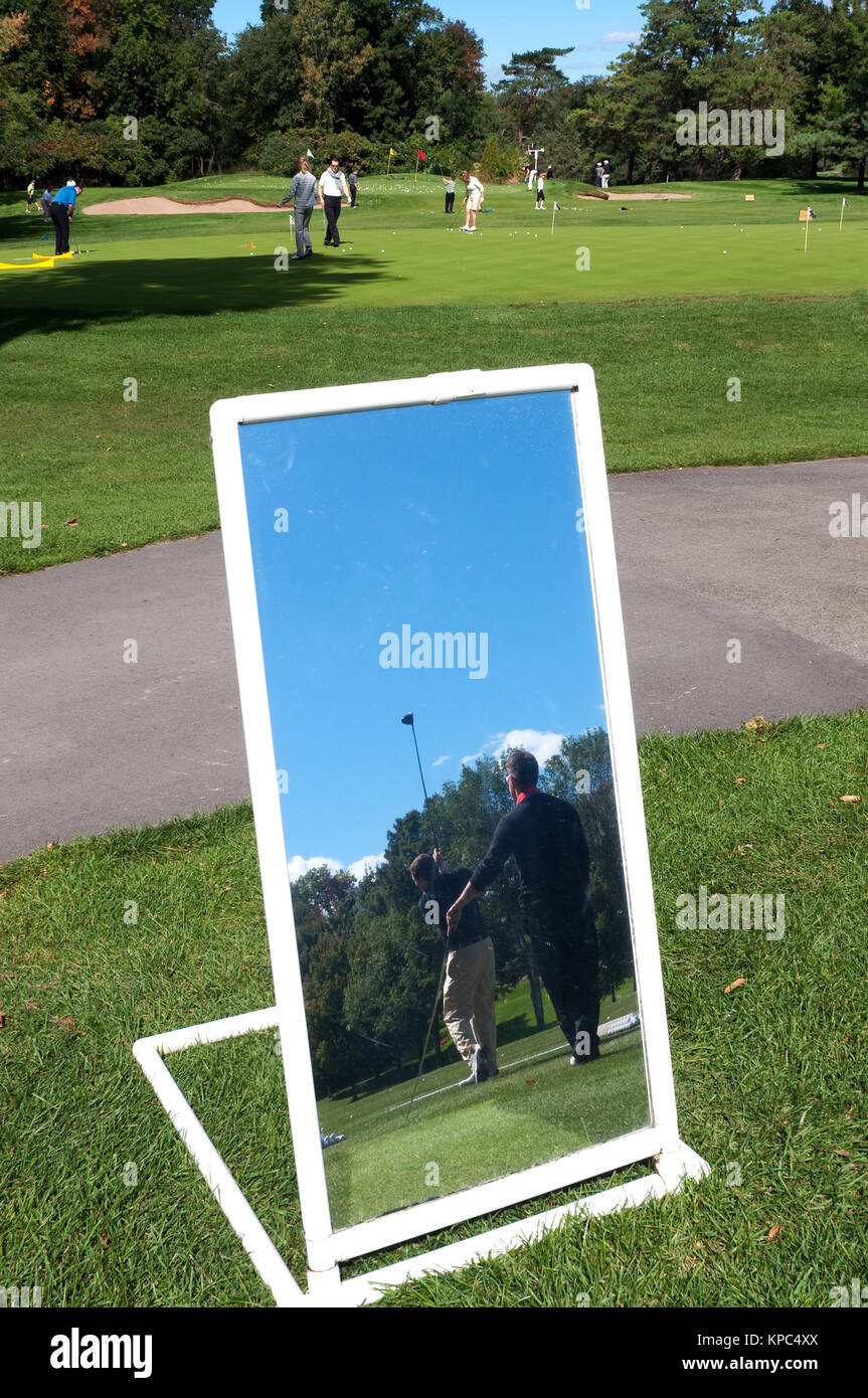 Golfspieler üben auf der Driving Range, in einem Spiegel für den Unterricht verwendet. Stockfoto